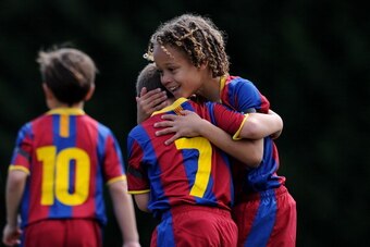 BARCELONA, SPAIN - MAY 15:  Eight-year-old Barcelona youth player Xavi Simons (R) celebrates a goal with a teammate againts Llongueras on one of the pitches at the Joan Camper training ground on May 15, 2011 in Barcelona, Spain. Every weekend various team