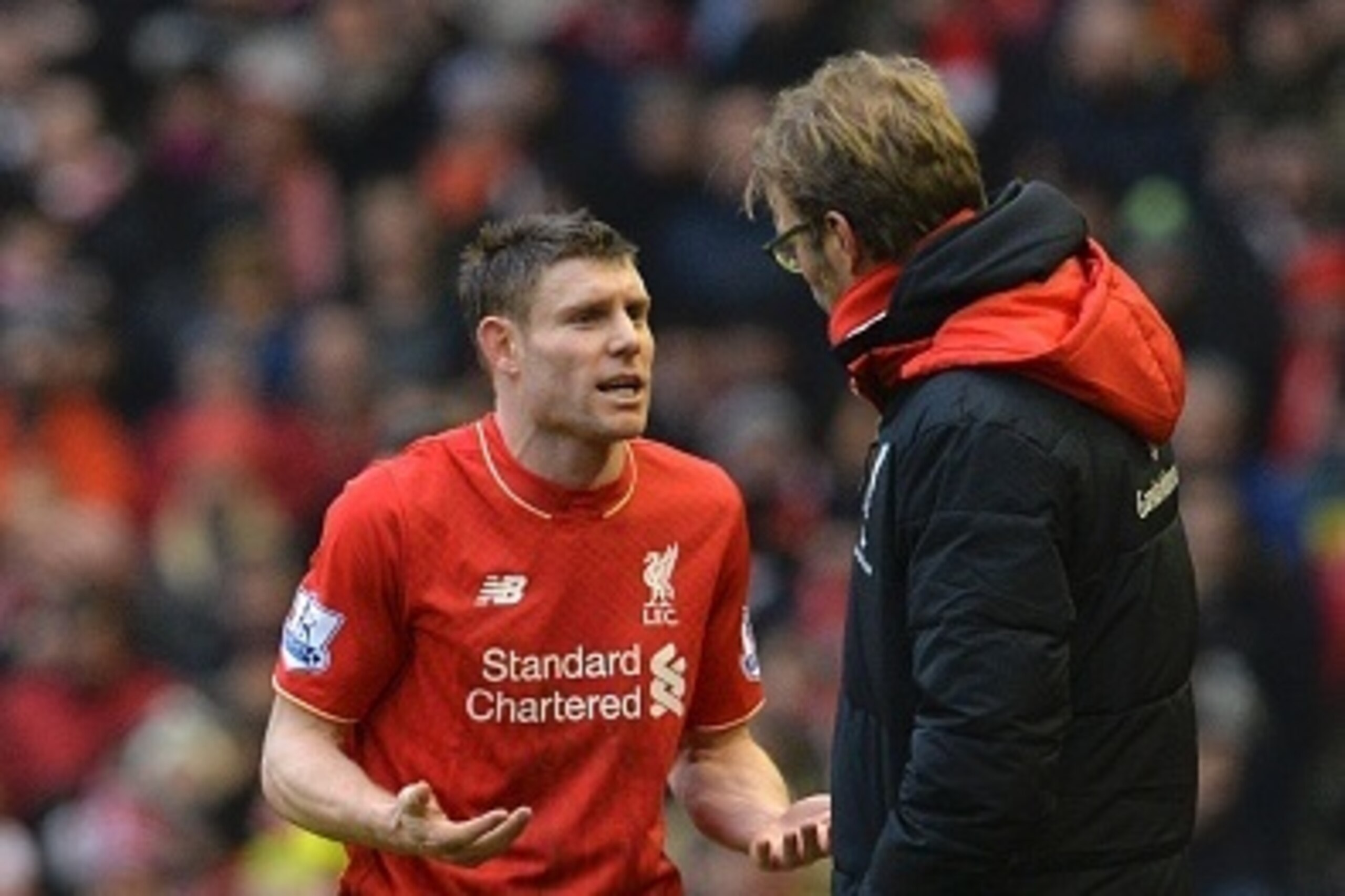 Liverpool's English midfielder James Milner (L) talks with Liverpool's German manager Jurgen Klopp (R) during a break in play during the English Premier League football match between Liverpool and Manchester United at Anfield in Liverpool, northwest Engla