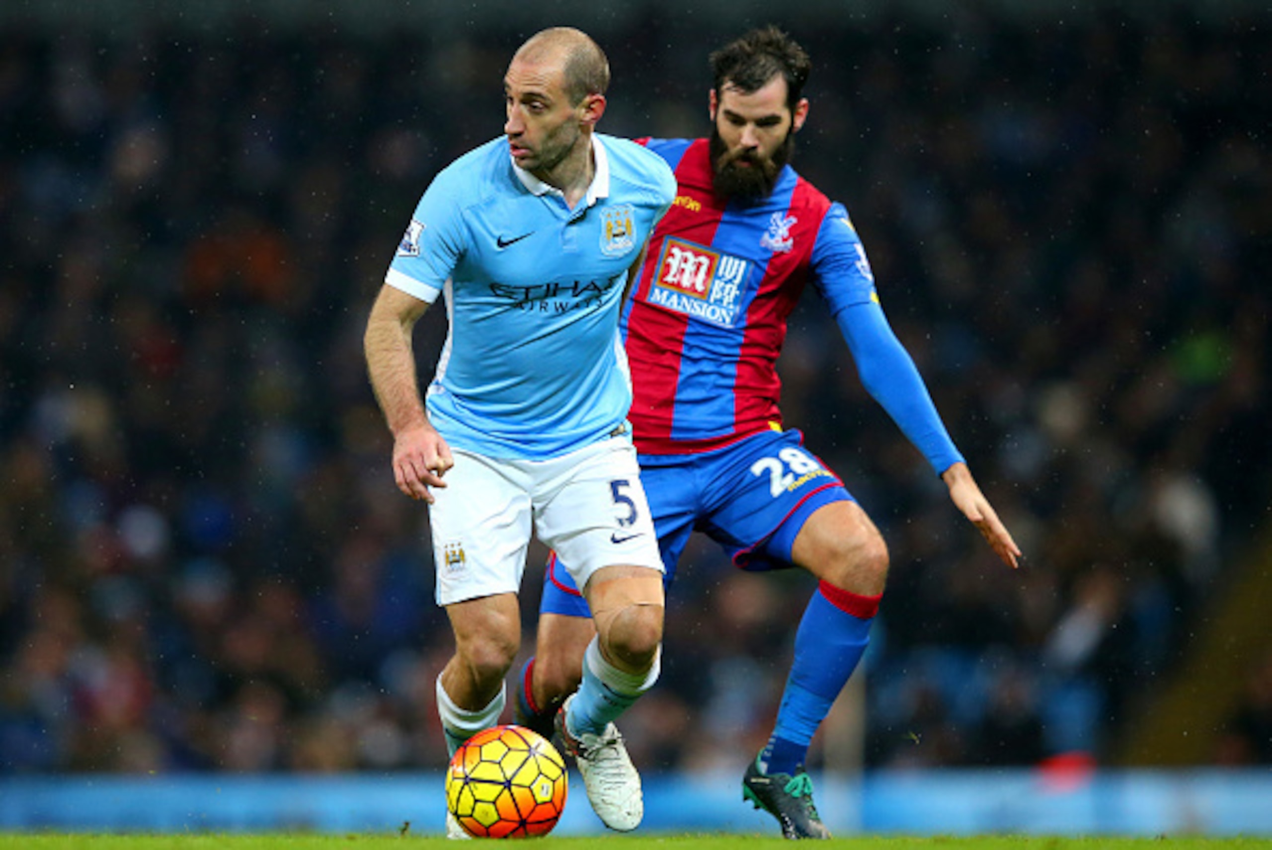 MANCHESTER, ENGLAND - JANUARY 16:  Pablo Zabaleta of Manchester City runs with the ball under pressure from Joe Ledley of Crystal Palace during the Barclays Premier League match between Manchester City and Crystal Palace at Etihad Stadium on January 16, 2