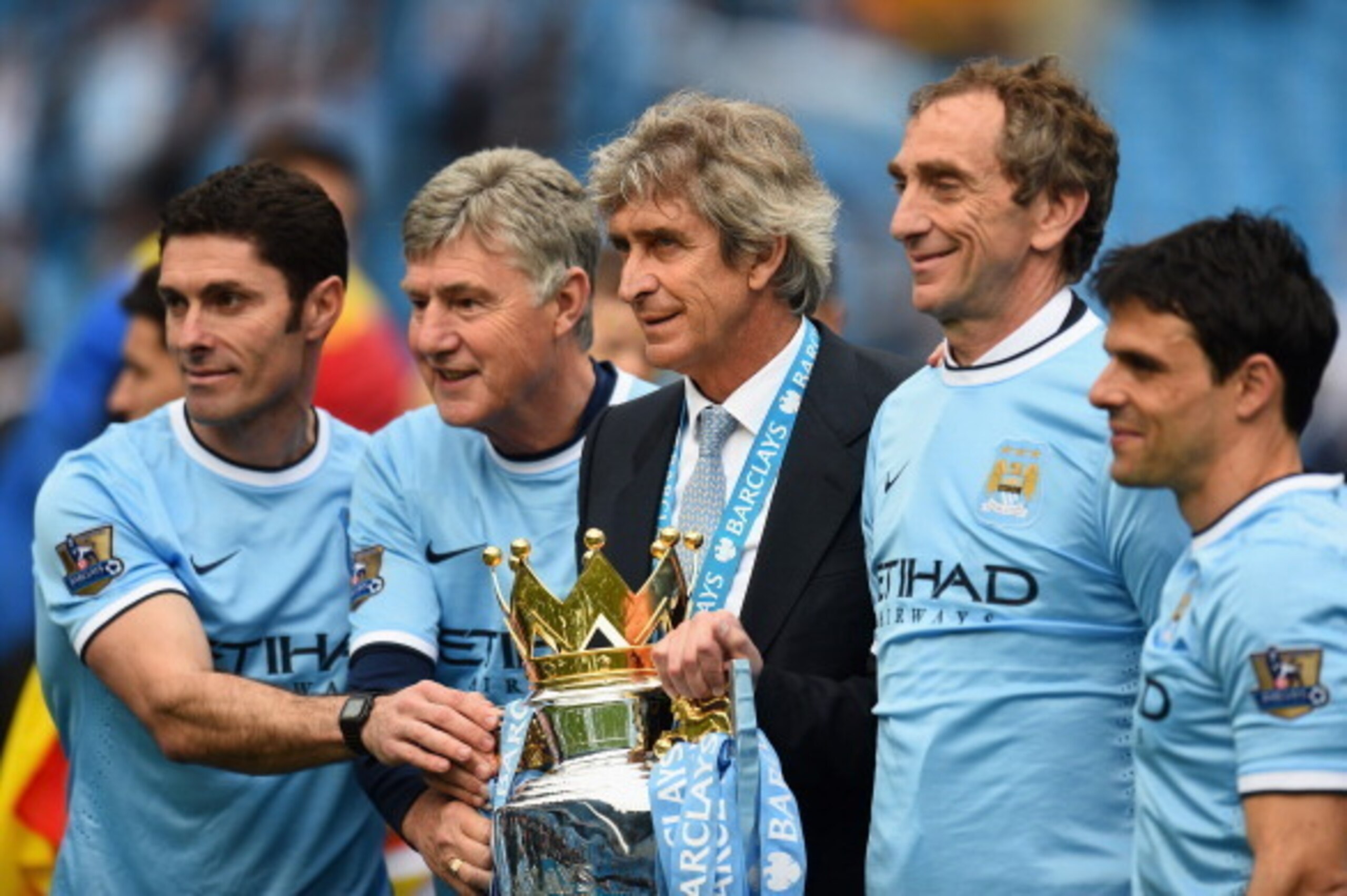 MANCHESTER, ENGLAND - MAY 11:  (L-R) Manchester City Goalkeeping Coach Xabier Mancisidor, Joint Assistant Manager Brian Kidd, Manager Manuel Pellegrini and Joint Assistant Manager Ruben Cousillas pose with the trophy after the Barclays Premier League matc
