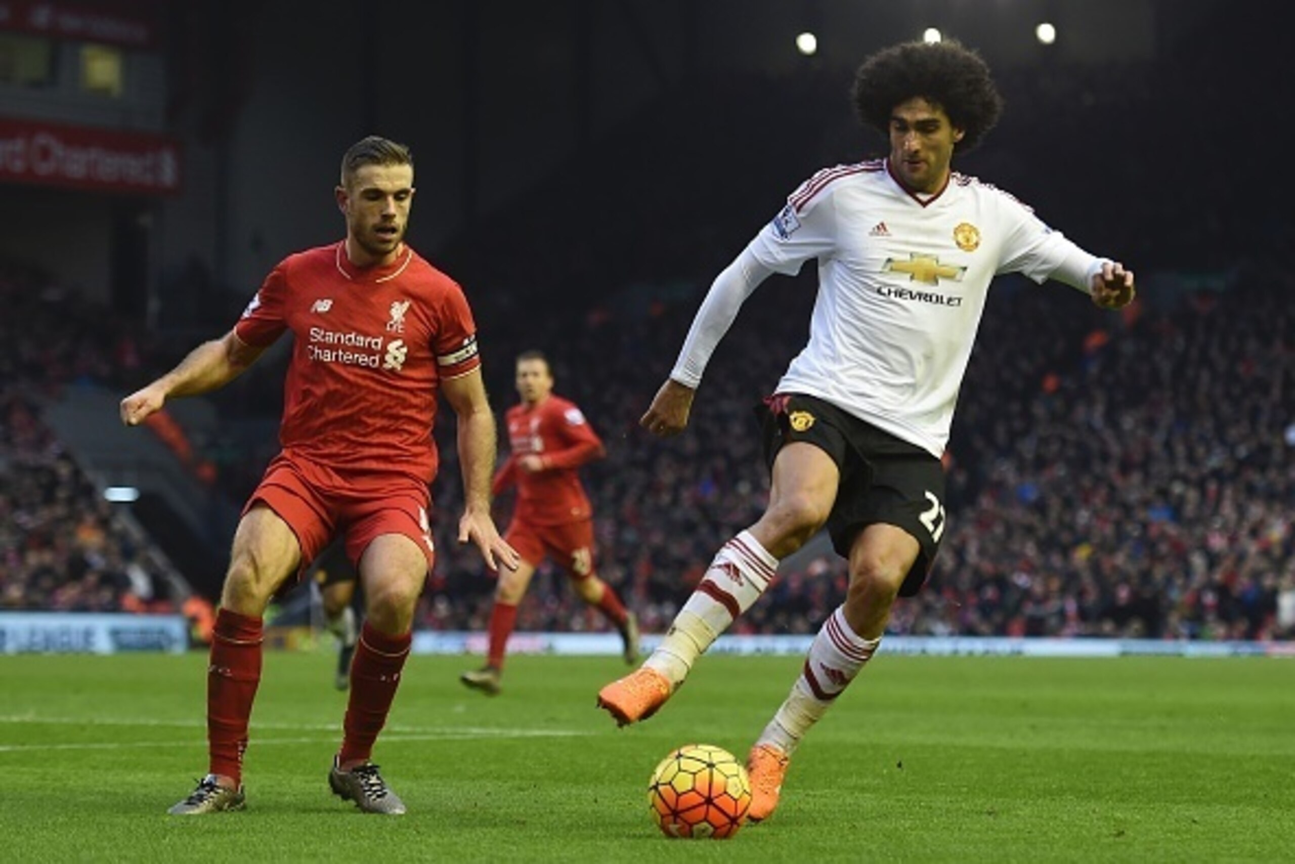 Manchester United's Belgian midfielder Marouane Fellaini (R) turns away from Liverpool's English midfielder Jordan Henderson (L) during the English Premier League football match between Liverpool and Manchester United at Anfield in Liverpool, northwest En