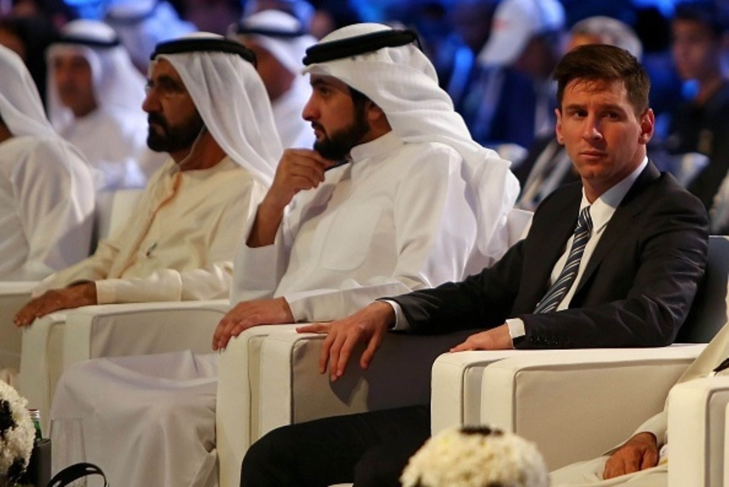Barcelona football striker Lionel Messi (R) sits next to Sheikh Ahmed Bin Mohamed Bin Rashid al-Maktoum (C) and his father Shiekh Mohamed Bin Rashid al-Maktoum, ruler of Dubai, during the opening session of the 10th edition of the Dubai International Spor