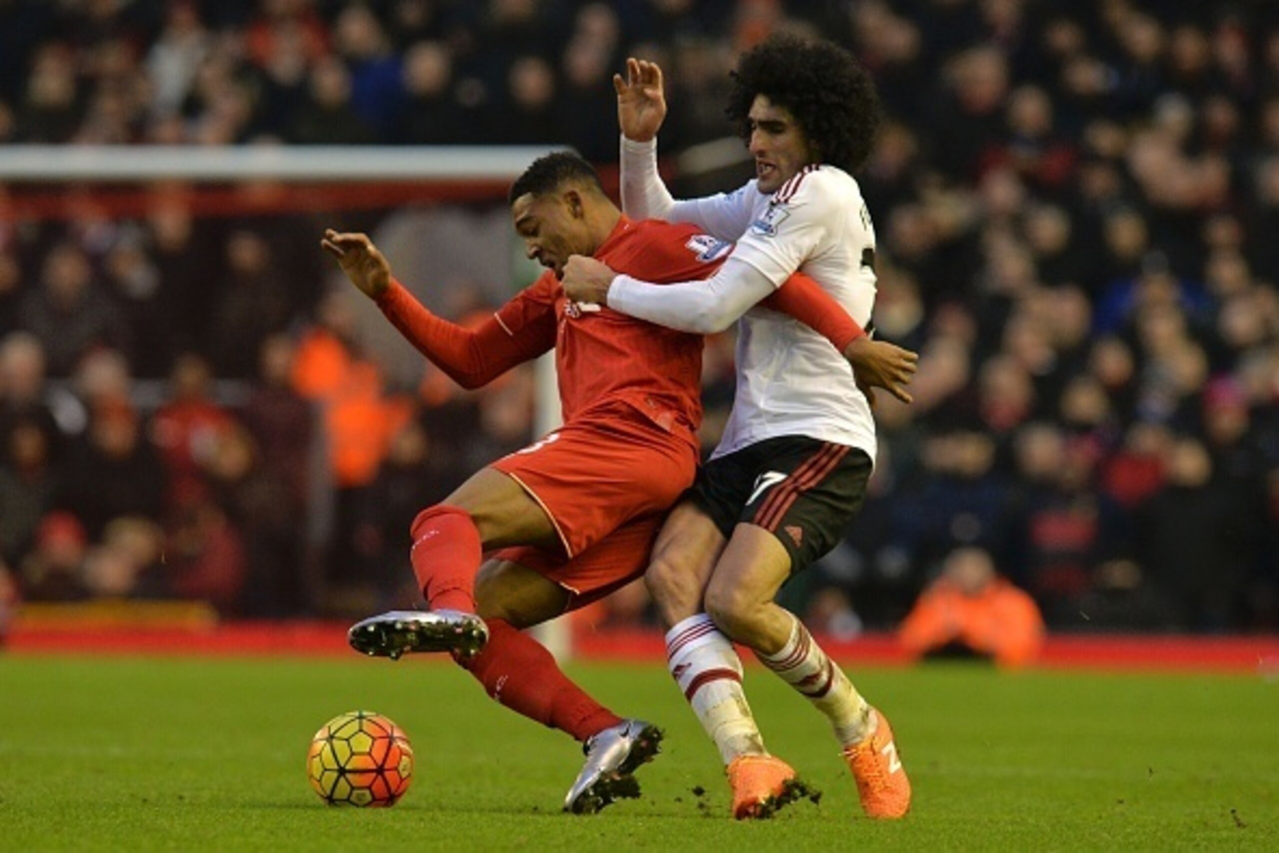 Manchester United's Belgian midfielder Marouane Fellaini (R) tangles with Liverpool's English midfielder Jordon Ibe (L) during the English Premier League football match between Liverpool and Manchester United at Anfield in Liverpool, northwest England, on