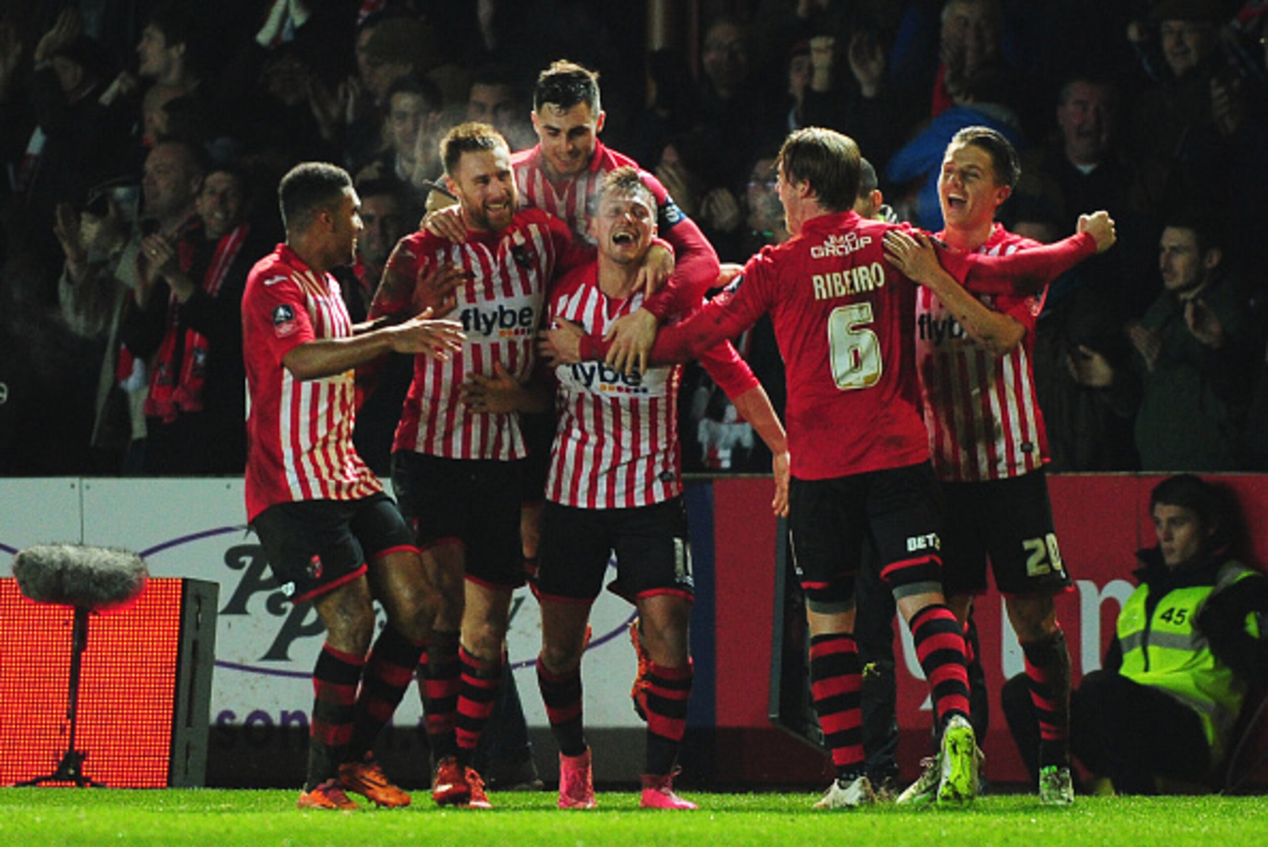 EXETER, ENGLAND - JANUARY 08:  Lee Holmes of Exeter City (C) celebrates with team mates as he scores their second goal during the Emirates FA Cup third round match between Exeter City and Liverpool at St James Park on January 8, 2016 in Exeter, England.  