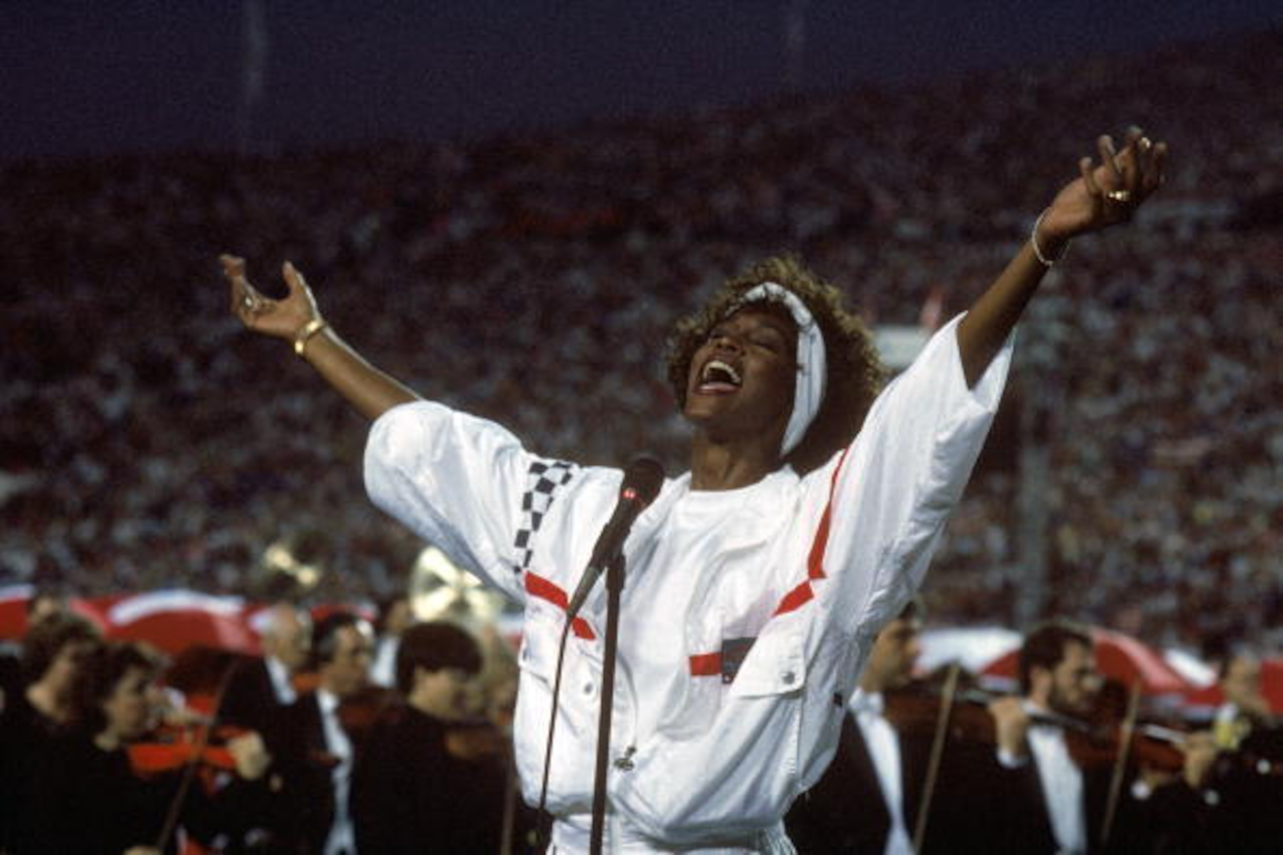 TAMPA, FL - JANUARY 27:  Whitney Houston sings the National Anthem before a game with the New York Giants taking on the Buffalo Bills prior to Super Bowl XXV at Tampa Stadium on January 27, 1991 in Tampa, Florida. The Giants won 20-19. (Photo by George Ro