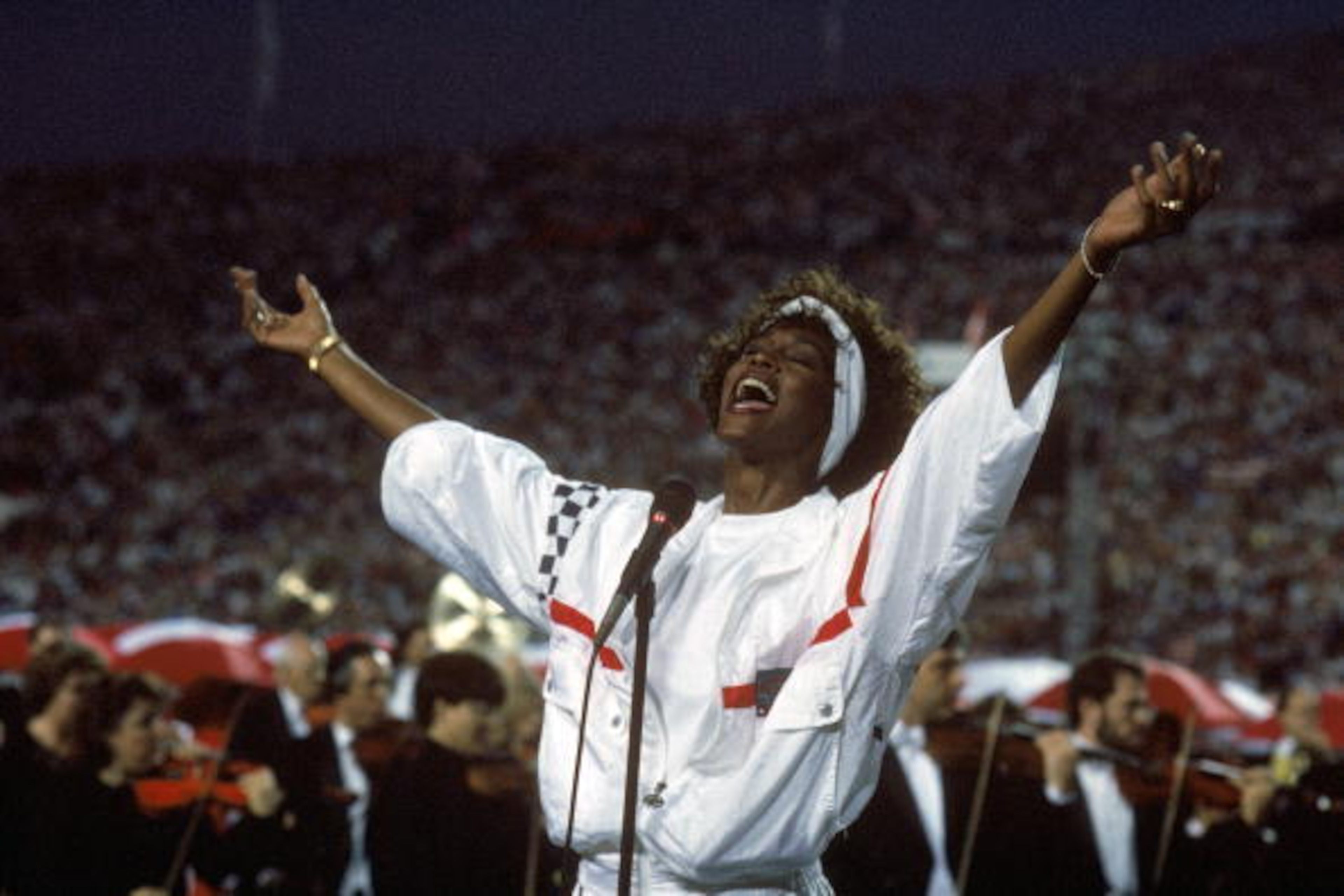 TAMPA, FL - JANUARY 27:  Whitney Houston sings the National Anthem before a game with the New York Giants taking on the Buffalo Bills prior to Super Bowl XXV at Tampa Stadium on January 27, 1991 in Tampa, Florida. The Giants won 20-19. (Photo by George Ro