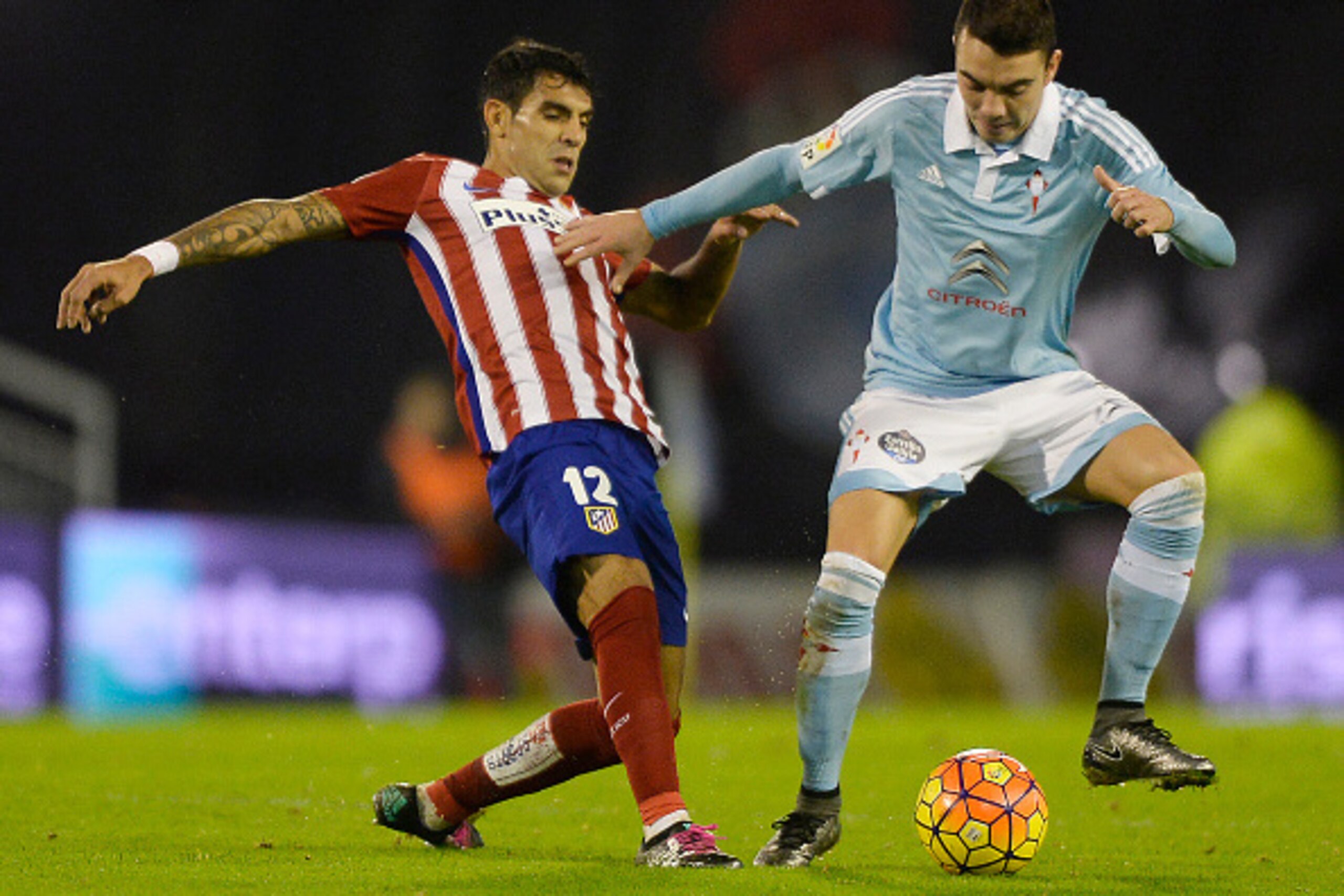 Atletico Madrid's Argentinian midfielder Augusto Fernandez (L) vies with Celta Vigo's forward Iago Aspas during the Spanish league football match RC Celta de Vigo vs Club Atletico de Madrid at the Balaidos stadium in Vigo on January 10, 2016.   AFP PHOTO/
