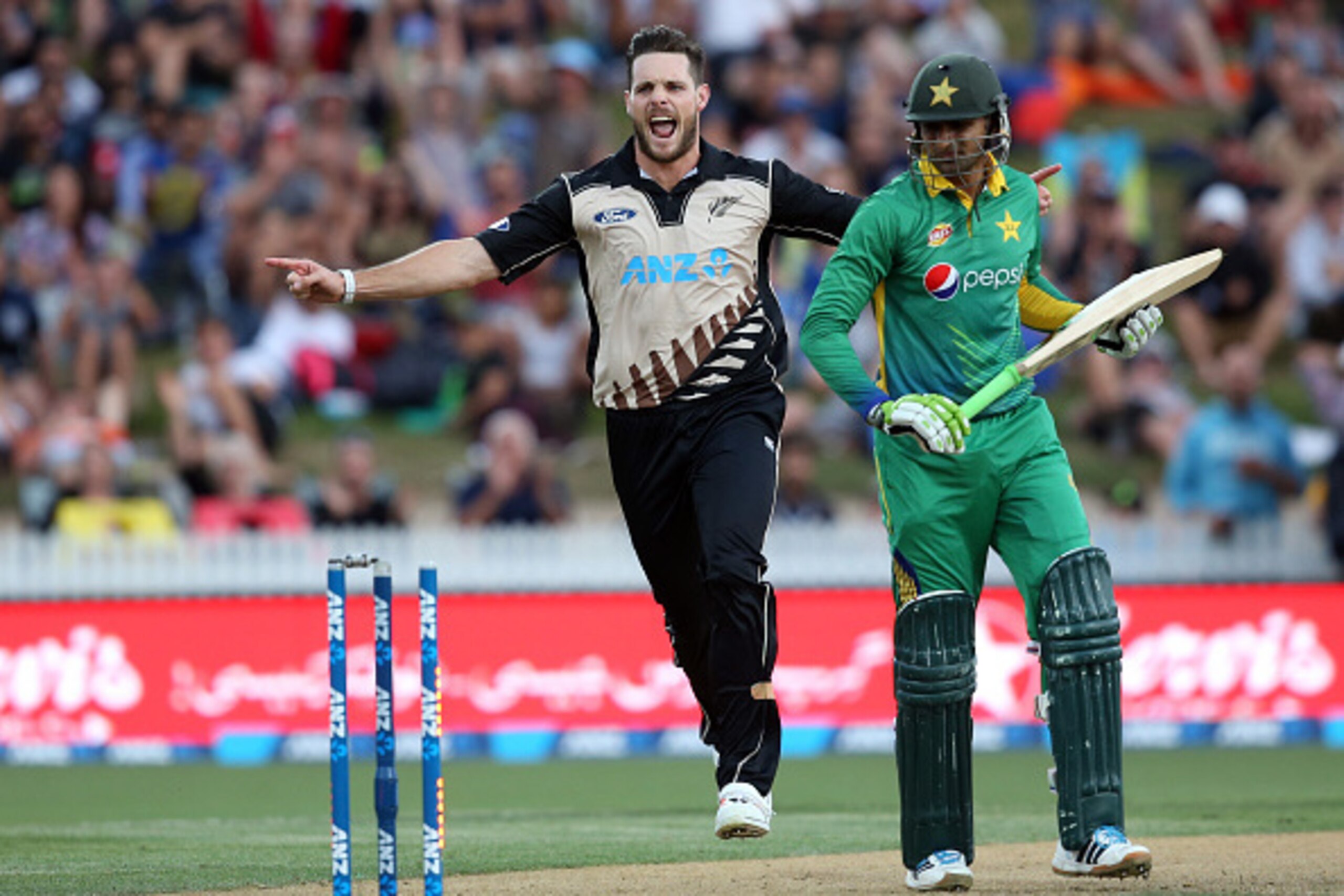 Shoaib Malik of Pakistan (R) looks back as he is bowled out by New Zealand's Mitchell McClenaghan (L) during the second Twenty20 cricket match between New Zealand and Pakistan at Seddon Park in Hamilton on January 17, 2016.   AFP PHOTO / MICHAEL BRADLEY /