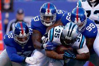 EAST RUTHERFORD, NJ - DECEMBER 20:   Mike Tolbert #35 of the Carolina Panthers gets tackled by Kerry Wynn #72, Jasper Brinkley #53 and Cullen Jenkins #99 of the New York Giants in the first half during their game at MetLife Stadium on December 20, 2015 in