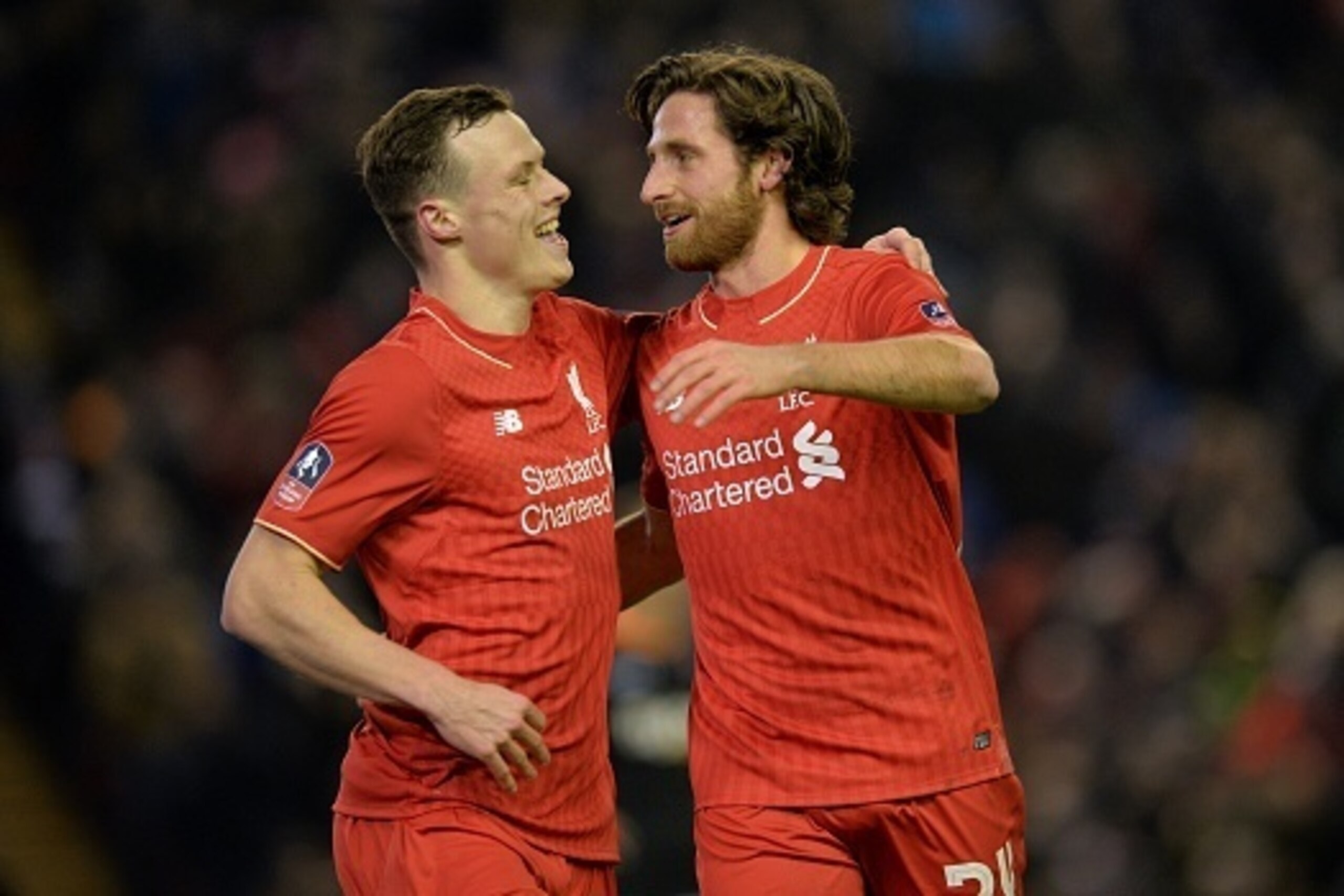 Liverpool's Welsh midfielder Joe Allen (R) celebrates with Liverpool's Australian defender Brad Smith after scoring the opening goal of the English FA Cup third round replay football match between Liverpool and Exeter City at Anfield in Liverpool, north w