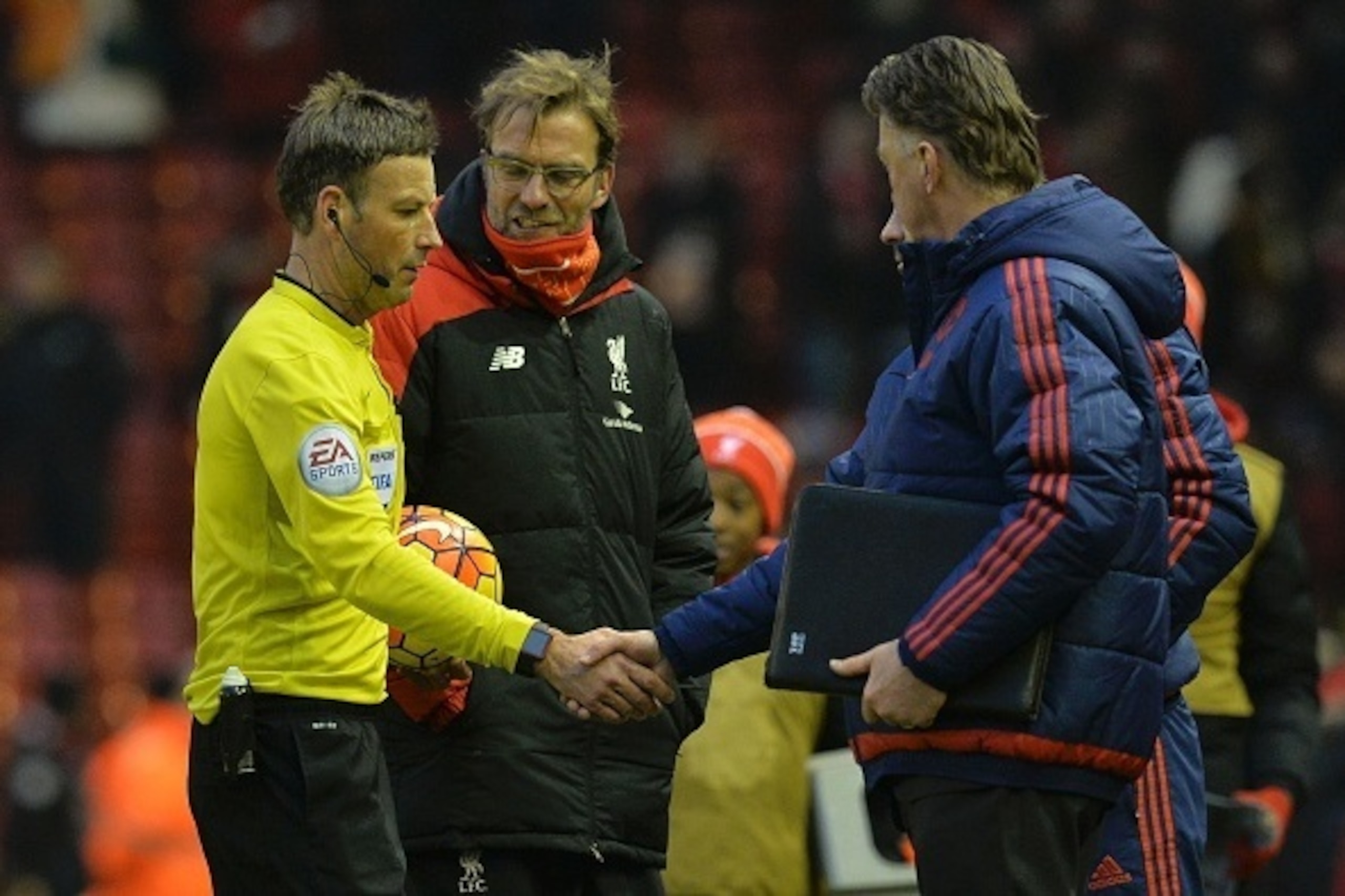 Manchester United's Welsh assistant manager Ryan Giggs (R obscured) shakes hands with referee Mark Clattenburg (L) as Manchester United's Dutch manager Louis van Gaal (R) and Liverpool's German manager Jurgen Klopp (2L) look on after the English Premier L