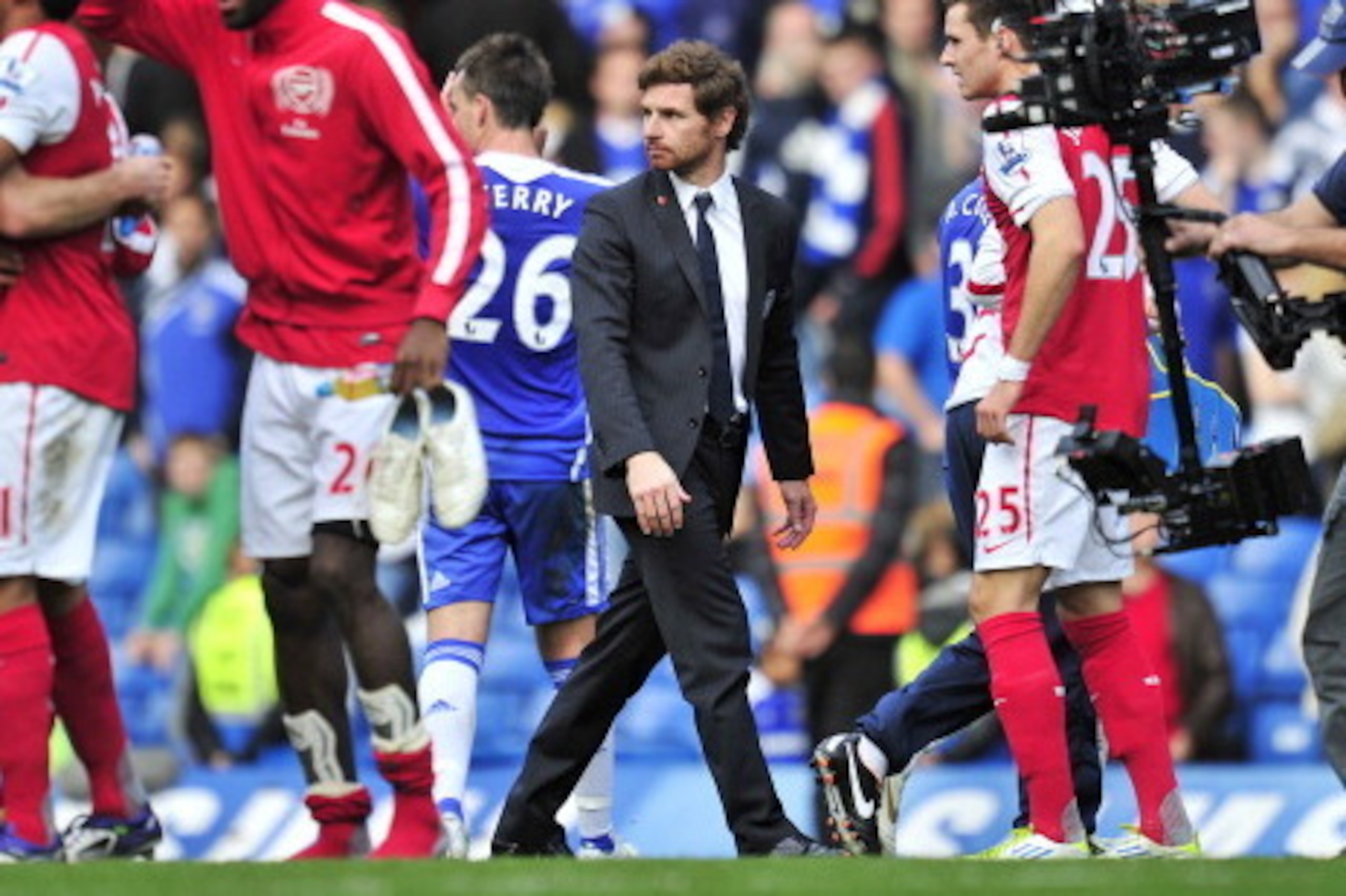 Chelsea's Portuguese manager Andre Villas-Boas (C) is seen on the pitch as Arsenal players celebrate their win in the English Premier League football match between Chelsea and Arsenal at Stamford Bridge in London, on October 29, 2011. Arsenal won the game