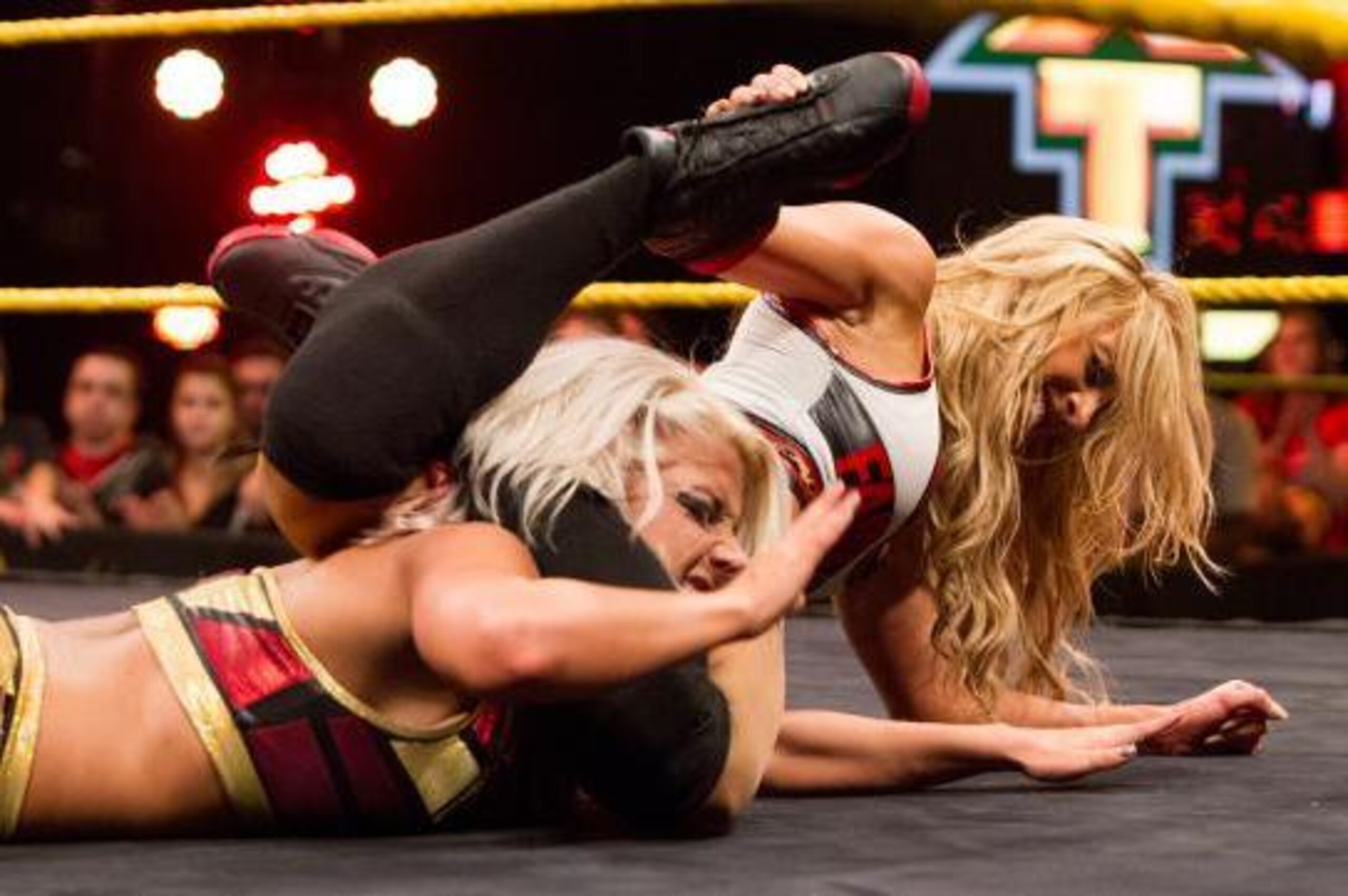 Carmella punishes Alexa Bliss with her finisher.