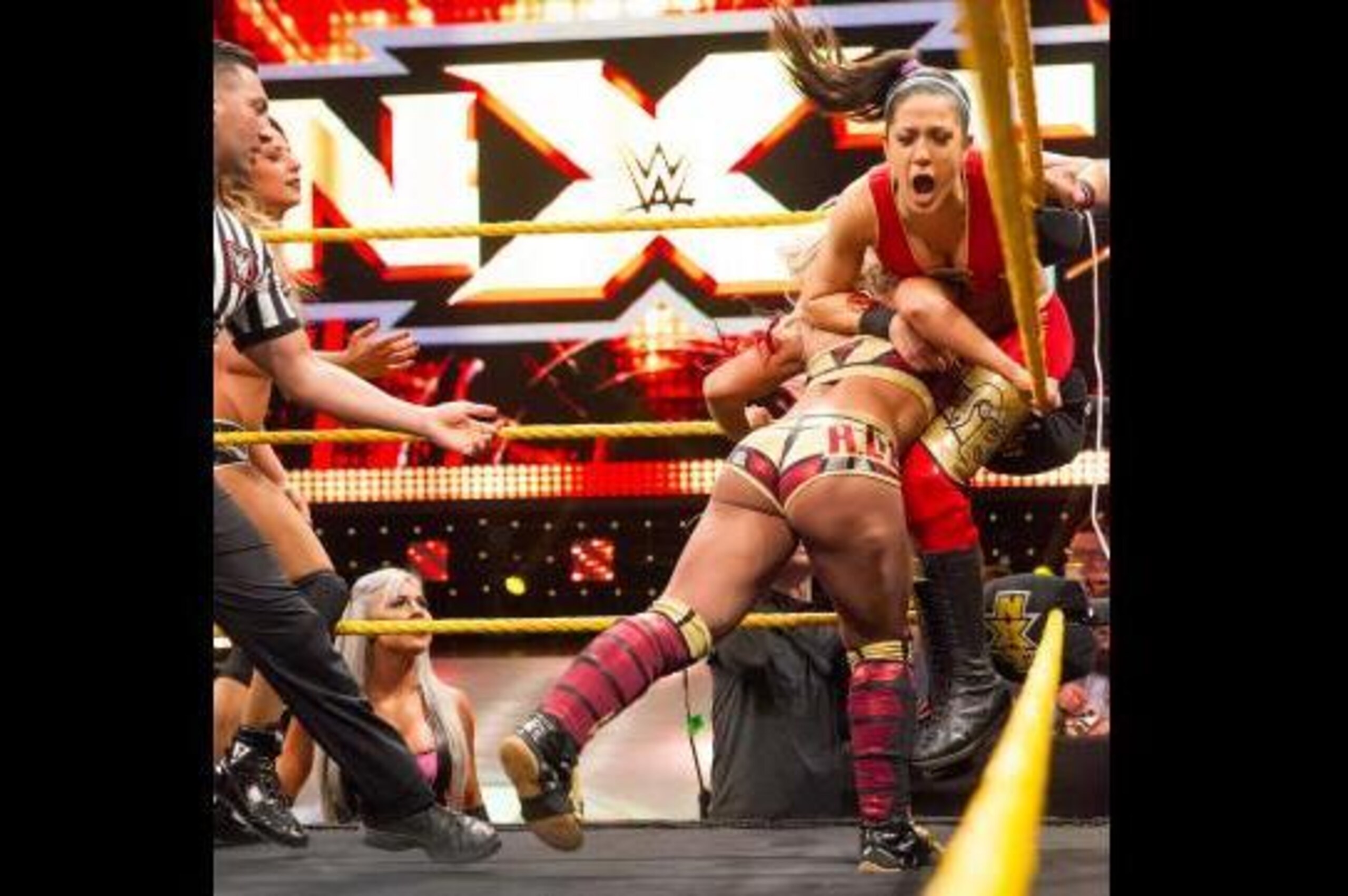 Alexa Bliss attacks Bayley in the corner.