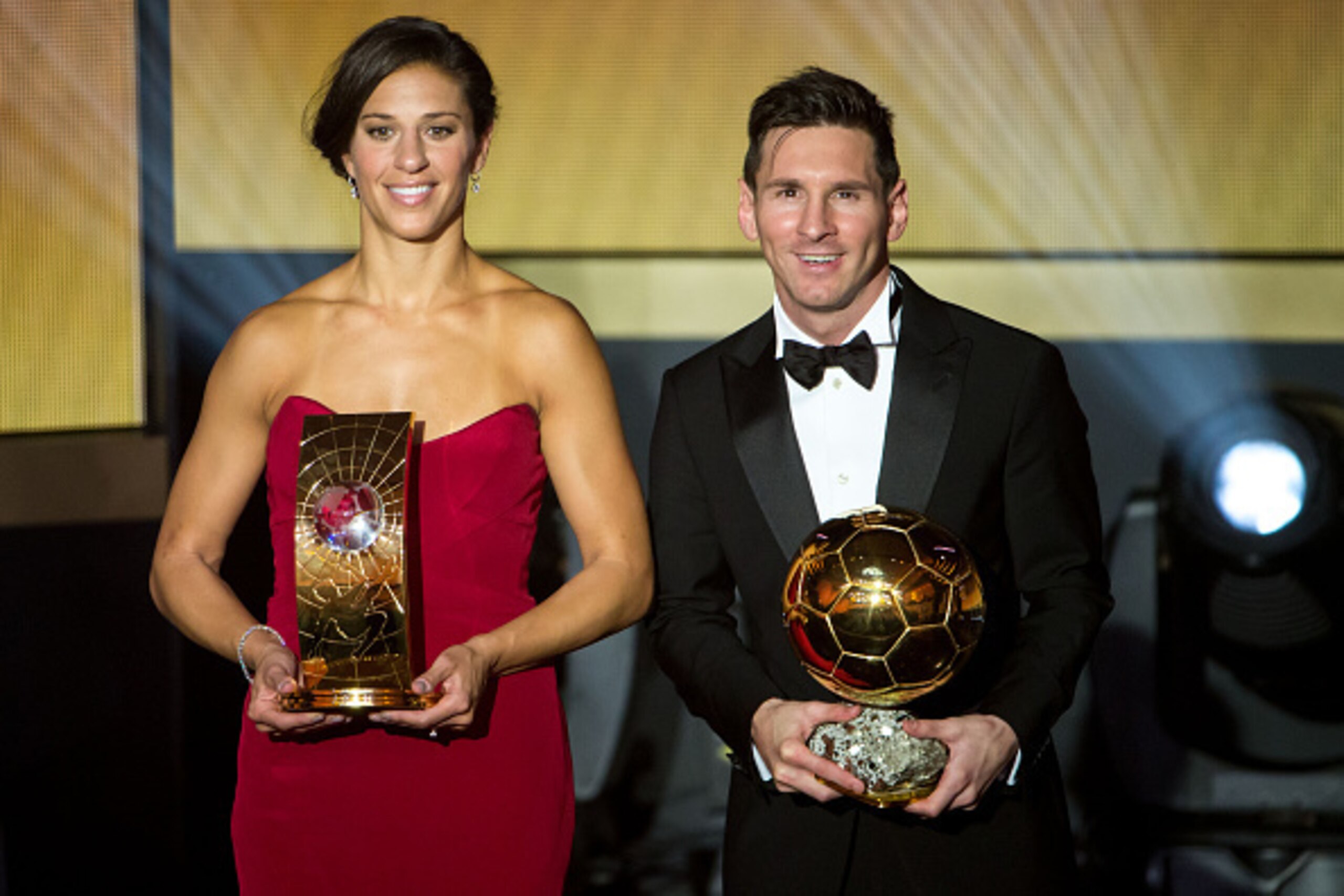 ZURICH, SWITZERLAND - JANUARY 11: FIFA Women's World Player of the Year winner Carli Lloyd of the USA and Houston Dash and FIFA Ballon d'Or winner Lionel Messi of Argentina and FC Barcelona pose together with their trophies after the FIFA Ballon d'Or Gala