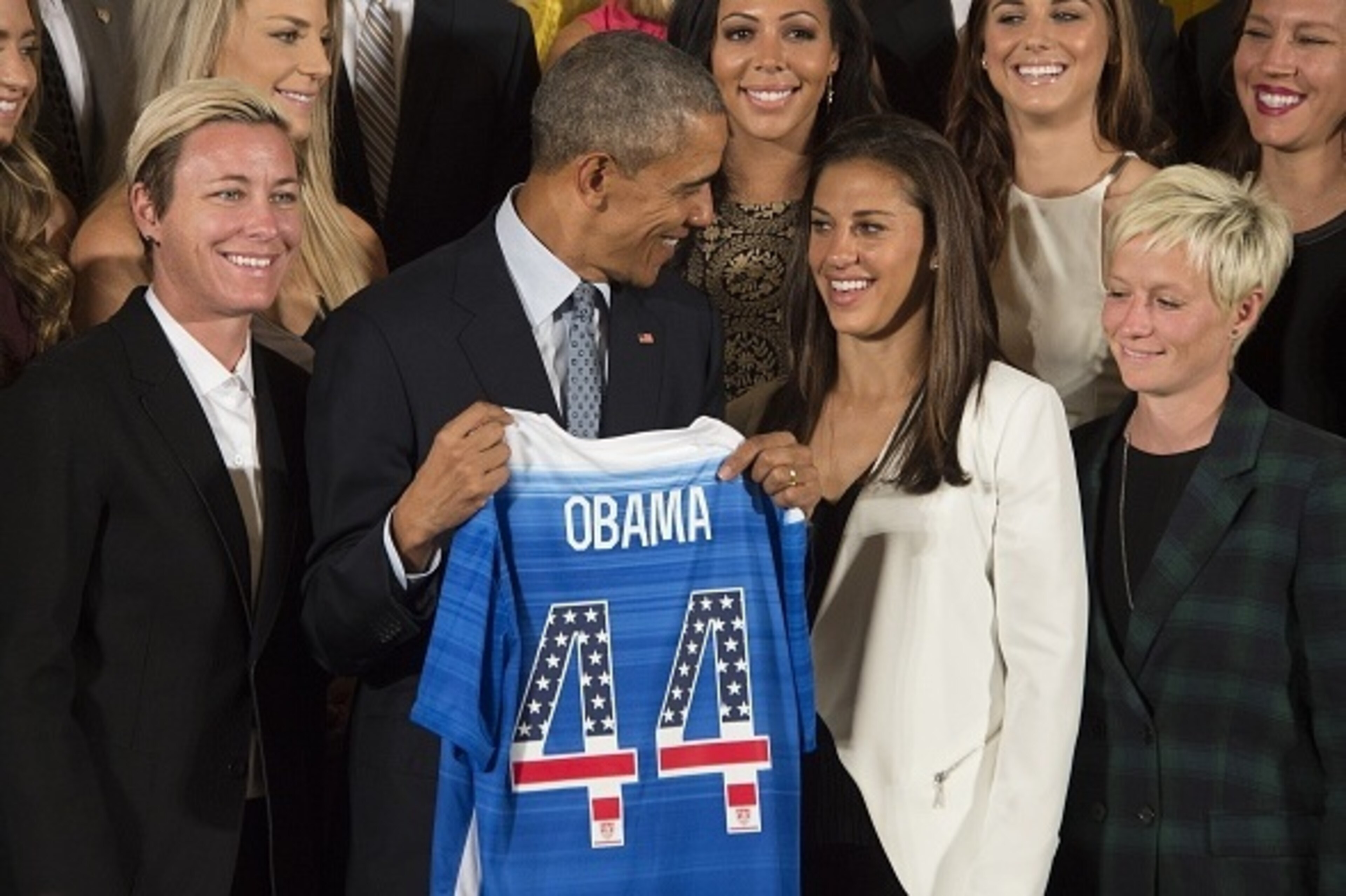 The US 2015 Women's World Cup Team's Abby Wambach (L) and Carli Lloyd (2nd R) present US President Barack Obama (C) with a team jersey during an event honoring them at the White House in Washington, DC, October 27, 2015.    AFP PHOTO / JIM WATSON        (