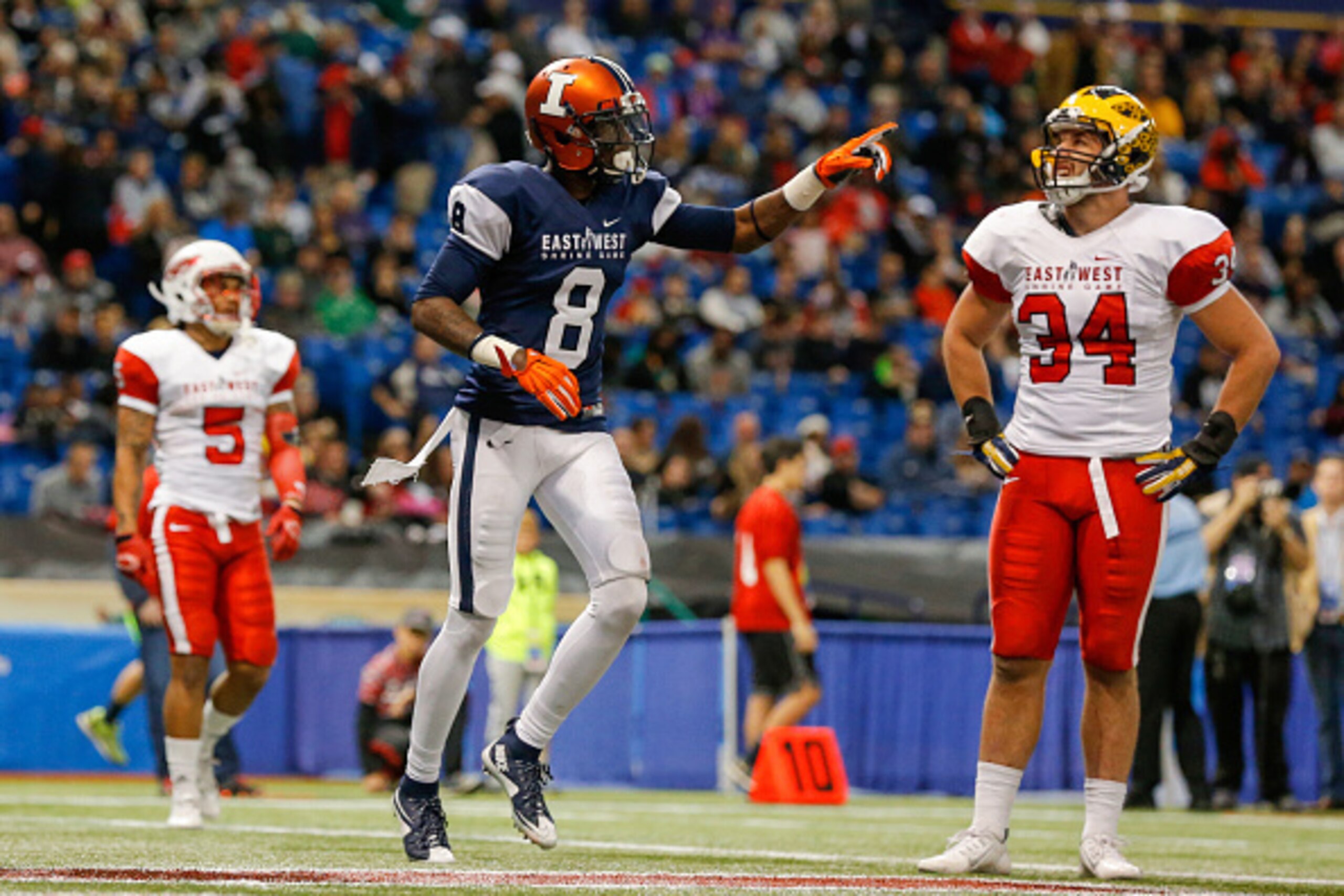 ST. PETERSBURG, FL - JANUARY 23:  Geronimo Allison #8 from Illinois playing on the West Team celebrates his touchdown as Joe Bolden #34 from Michigan playing on the East Team reacts during the second half of the East West Shrine Game at Tropicana Field on