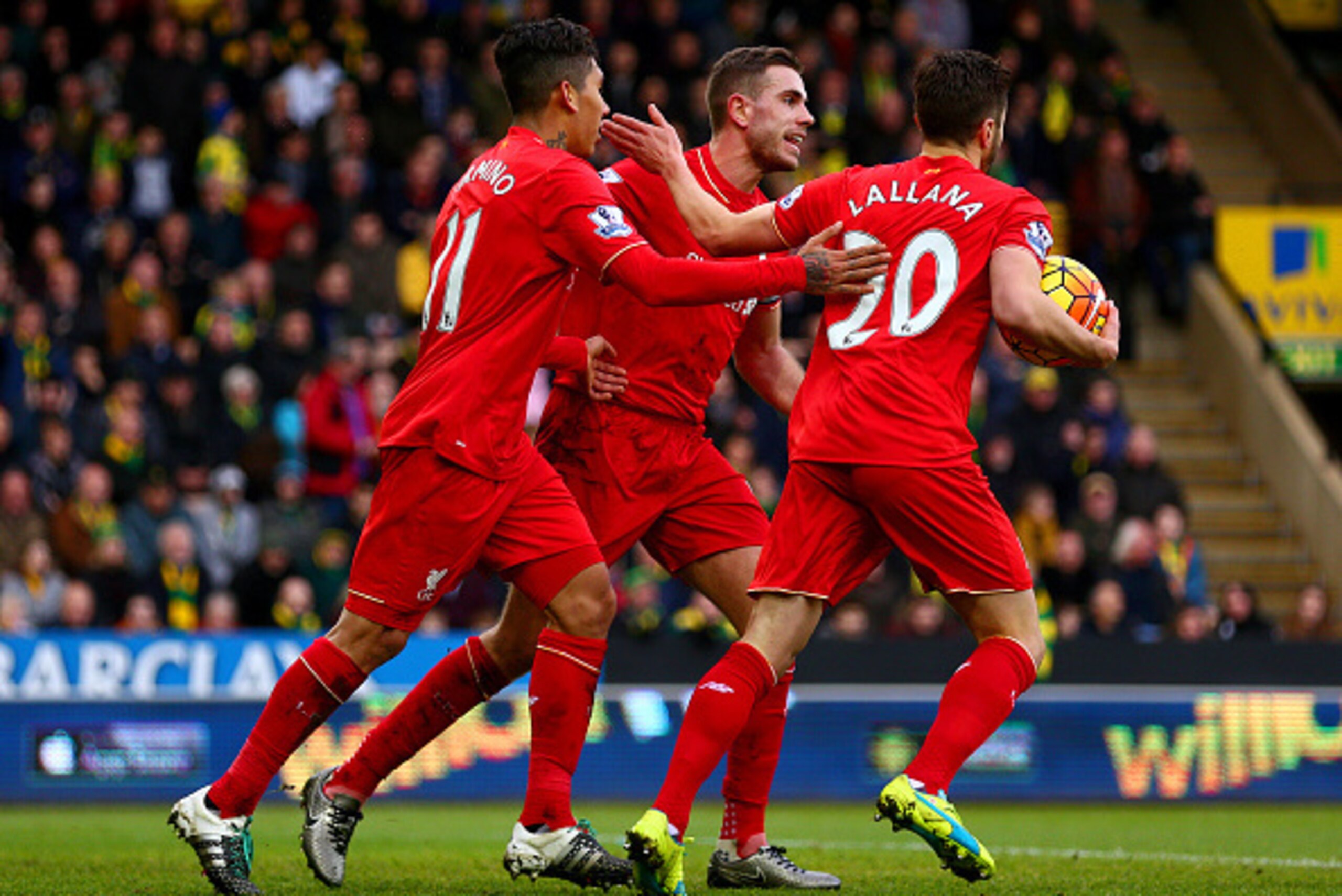 NORWICH, ENGLAND - JANUARY 23: Roberto Firmino (L) of Liverpool ceelbrates scoring his team's third goal with his team mates Jordan Henderson (C) and Adam Lallana (R) during the Barclays Premier League match between Norwich City and Liverpool at Carrow Ro
