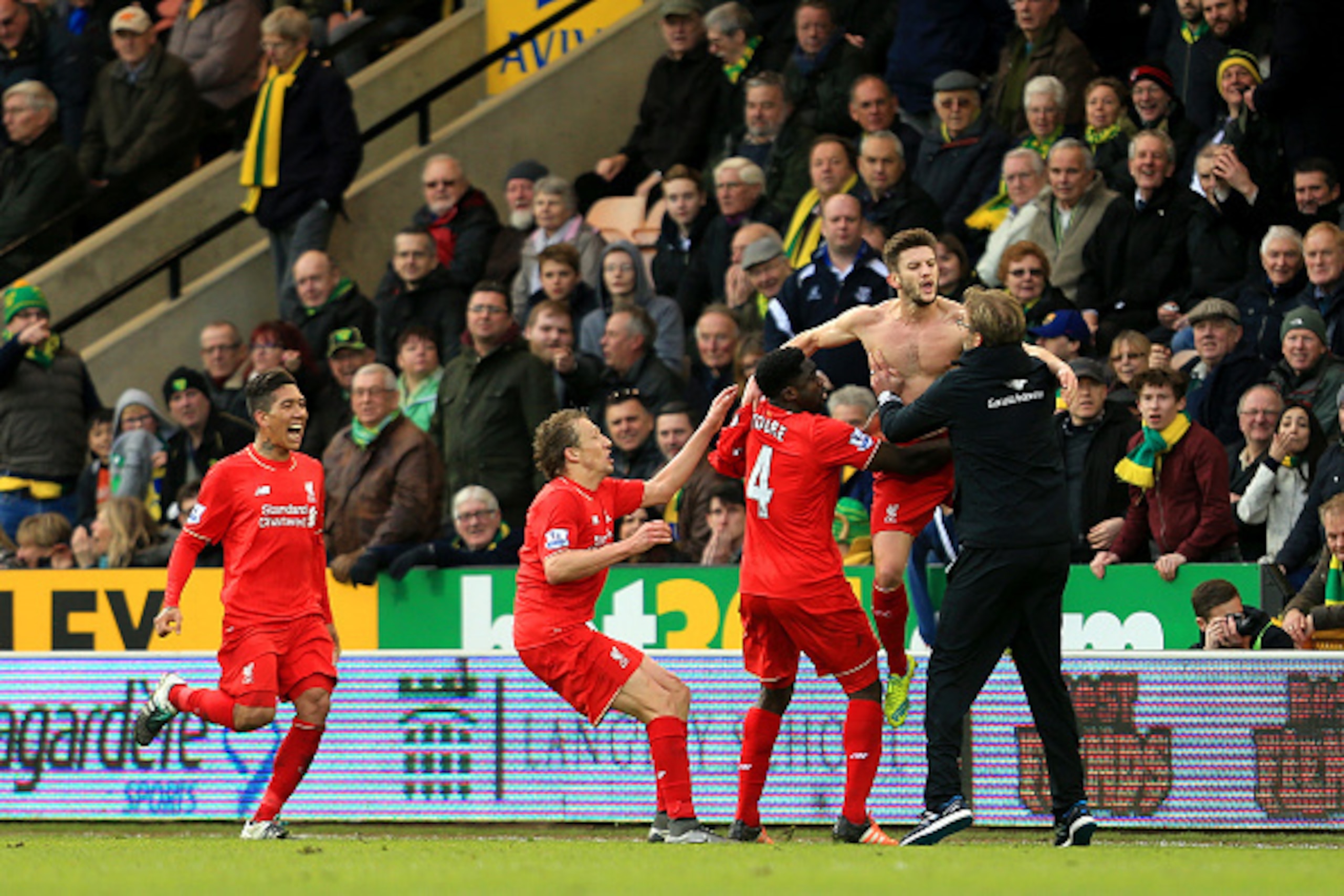 NORWICH, ENGLAND - JANUARY 23:  Adam Lallana (2nd R) of Liverpool ceelbrates scoring his team's fifth goal with his manager Jurgen Klopp (1st R) and team mate Kolo Toure (3rd R), Lucas Leiva (2nd L) and Roberto Firmino (1st L) during the Barclays Premier 
