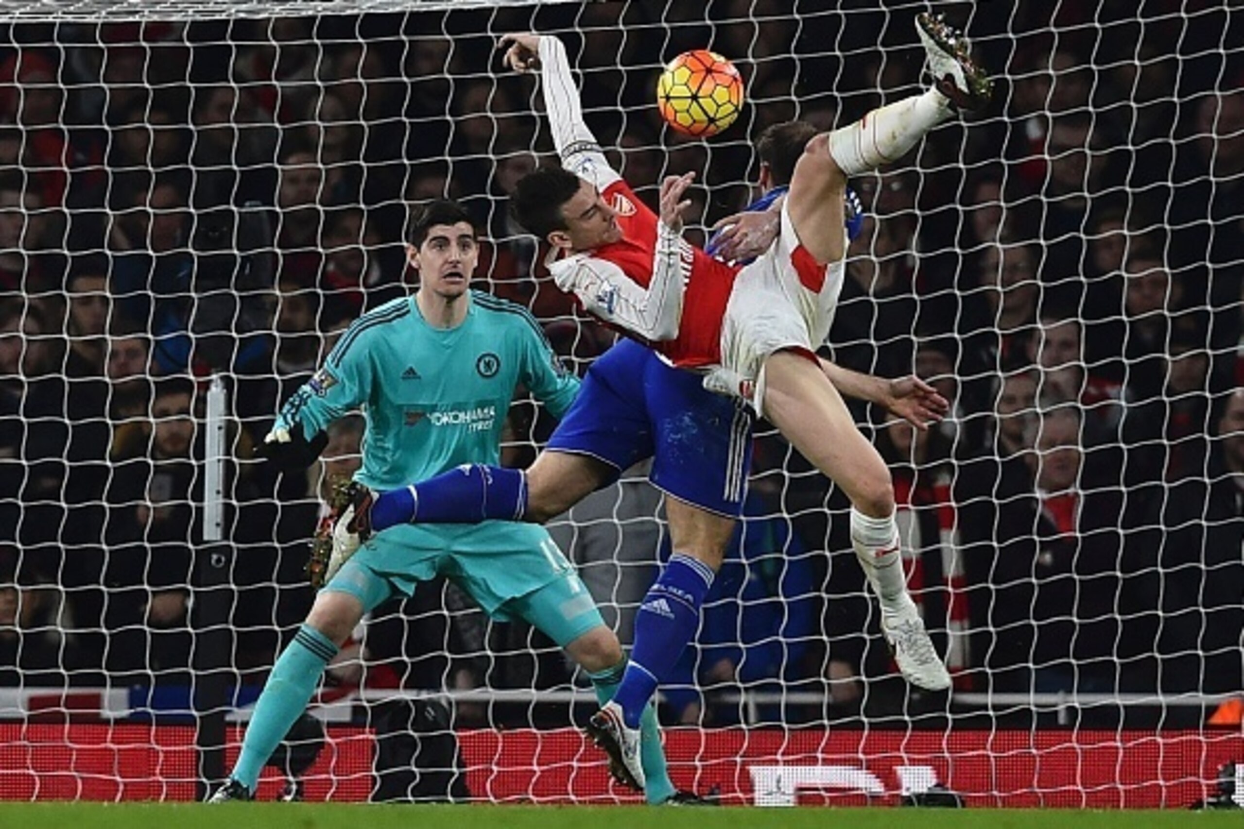 Arsenal's French defender Laurent Koscielny vies with Chelsea's Serbian defender Branislav Ivanovic as Chelsea's Belgian goalkeeper Thibaut Courtois (L) looks on during the English Premier League football match between Arsenal and Chelsea at the Emirates Arsenal's French defender Laurent Koscielny vies with Chelsea's Serbian defender Branislav Ivanovic as Chelsea's Belgian goalkeeper Thibaut Courtois (L) looks on during the English Premier League football match between Arsenal and Chelsea at the Emirates