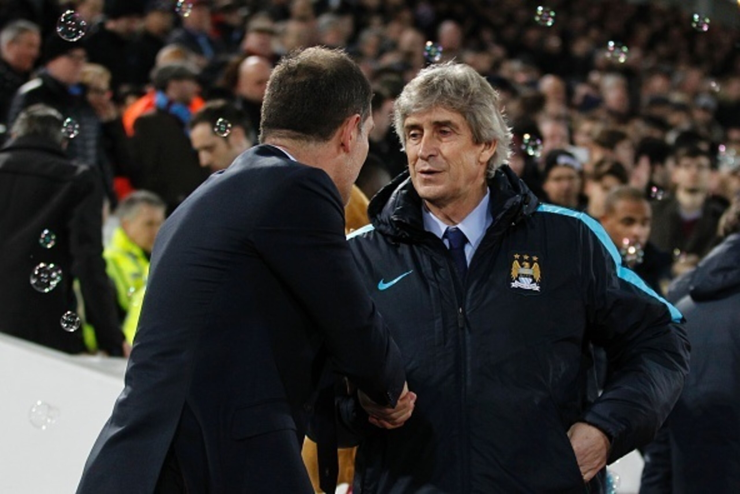 Manchester City's Chilean manager Manuel Pellegrini (R) is greeted by West Ham United's Croatian manager Slaven Bilic (L) for the English Premier League football match between West Ham United and Manchester City at The Boleyn Ground in Upton Park, in east