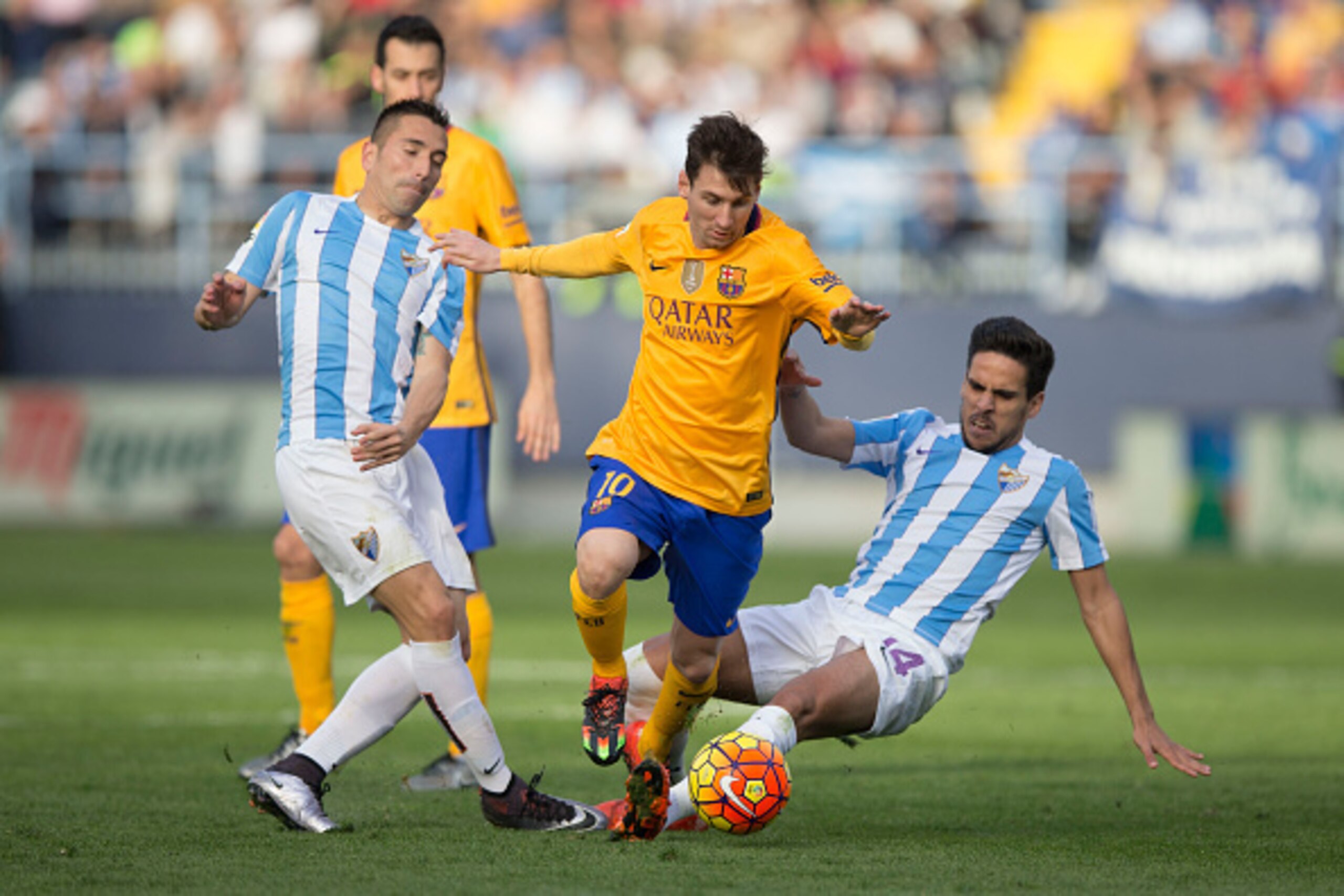 MALAGA, SPAIN - JANUARY 23:  Lionel Messi (2ndL) of FC Barcelona competes for the ball with Charles Dias de Oliveira of Malaga CF (L) and his teammate Jose Luis Garcia alias Recio (R) during the La Liga match between Malaga CF and FC Barcelona at La Rosal