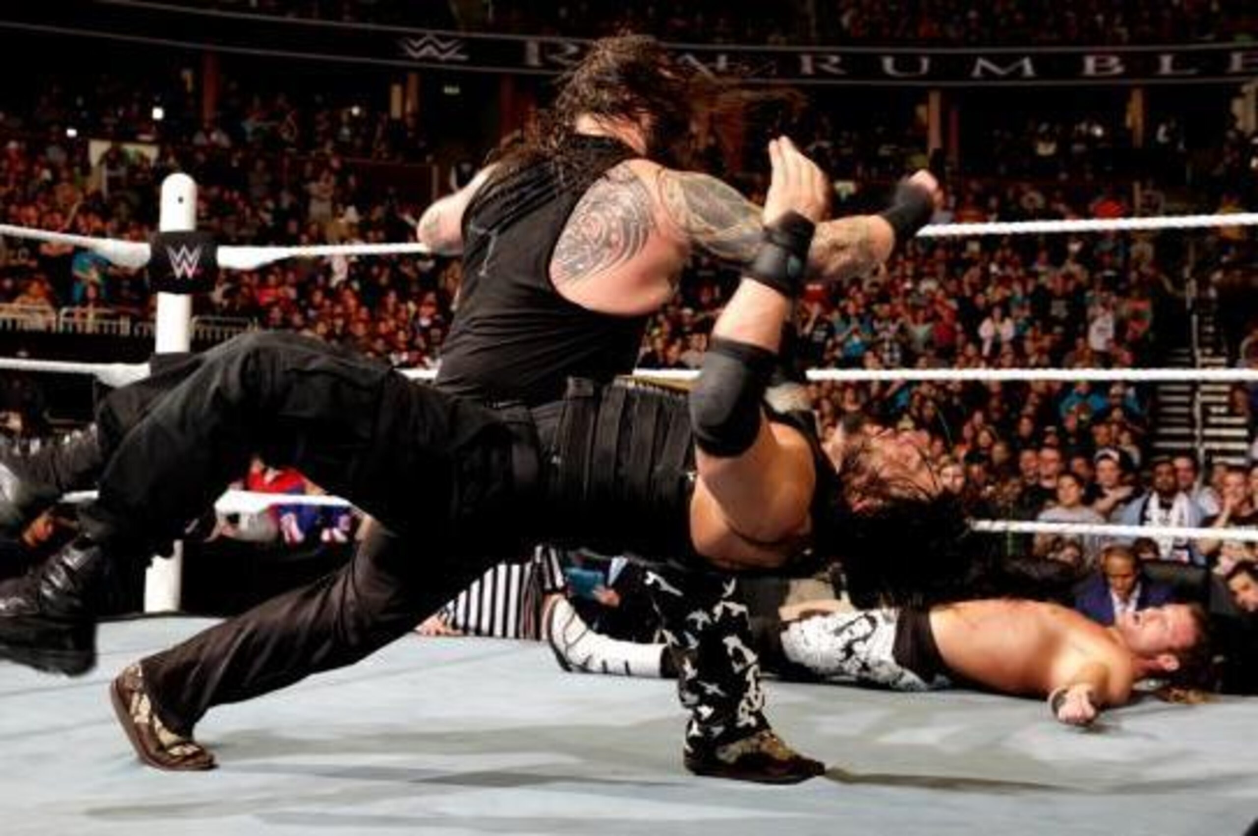 Bray Wyatt lays out Roman Reigns with a clothesline.