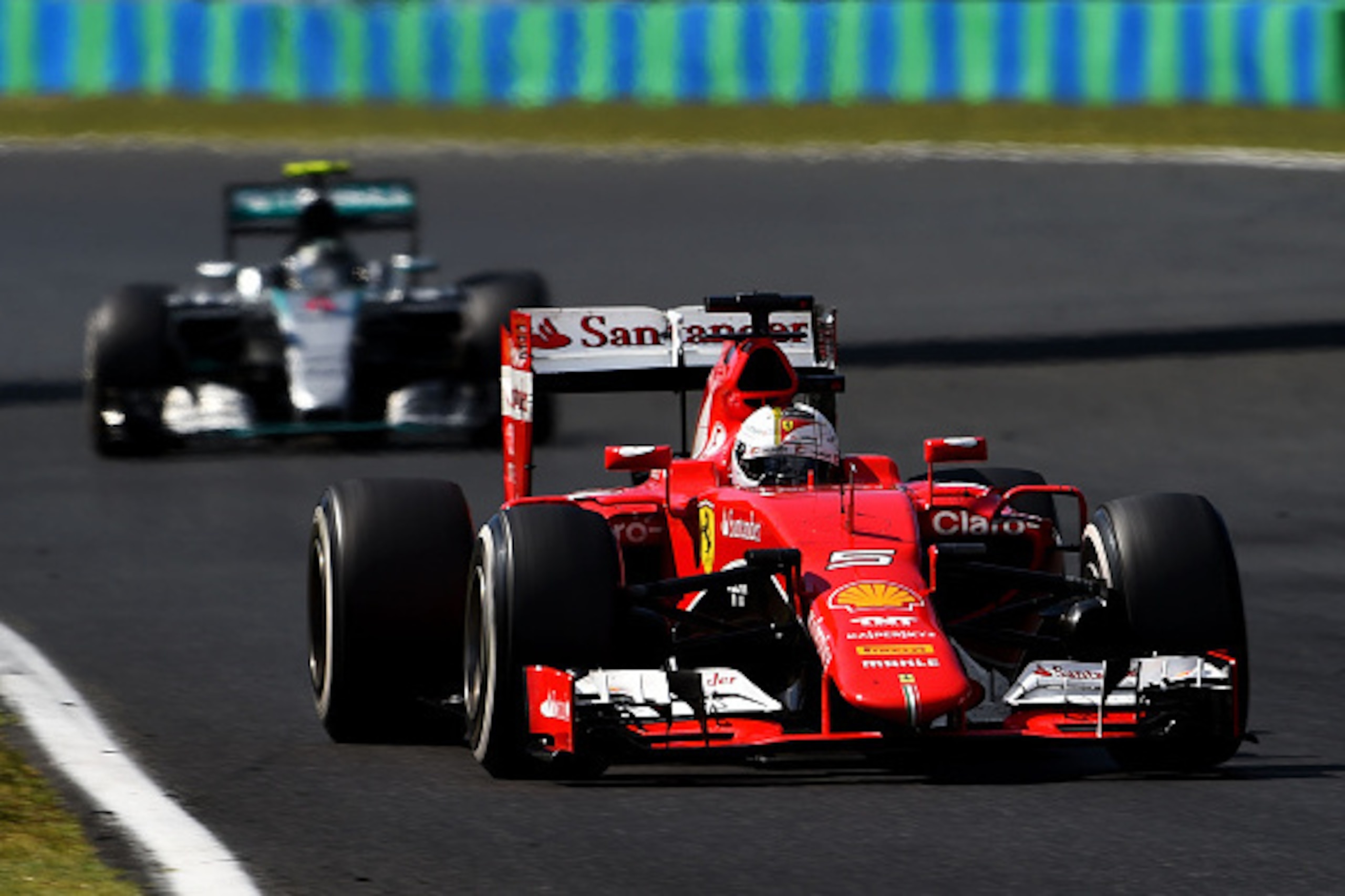 BUDAPEST, HUNGARY - JULY 26:  Sebastian Vettel of Germany and Ferrari drives ahead of Nico Rosberg of Germany and Mercedes GP during the Formula One Grand Prix of Hungary at Hungaroring on July 26, 2015 in Budapest, Hungary.  (Photo by Lars Baron/Getty Im