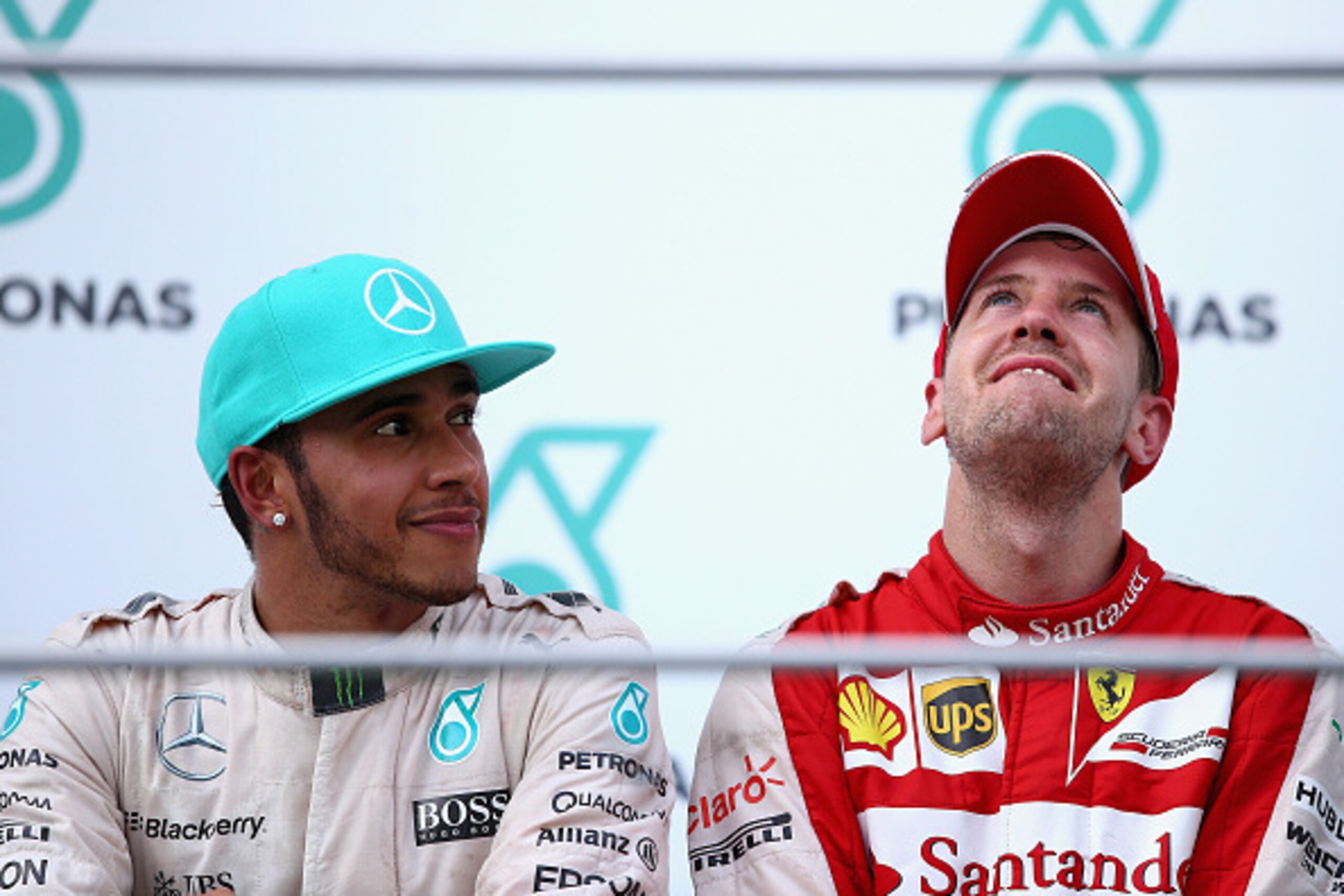 KUALA LUMPUR, MALAYSIA - MARCH 29:  Sebastian Vettel of Germany and Ferrari celebrates on the podium next to Lewis Hamilton of Great Britain and Mercedes GP after winning the Malaysia Formula One Grand Prix at Sepang Circuit on March 29, 2015 in Kuala Lum