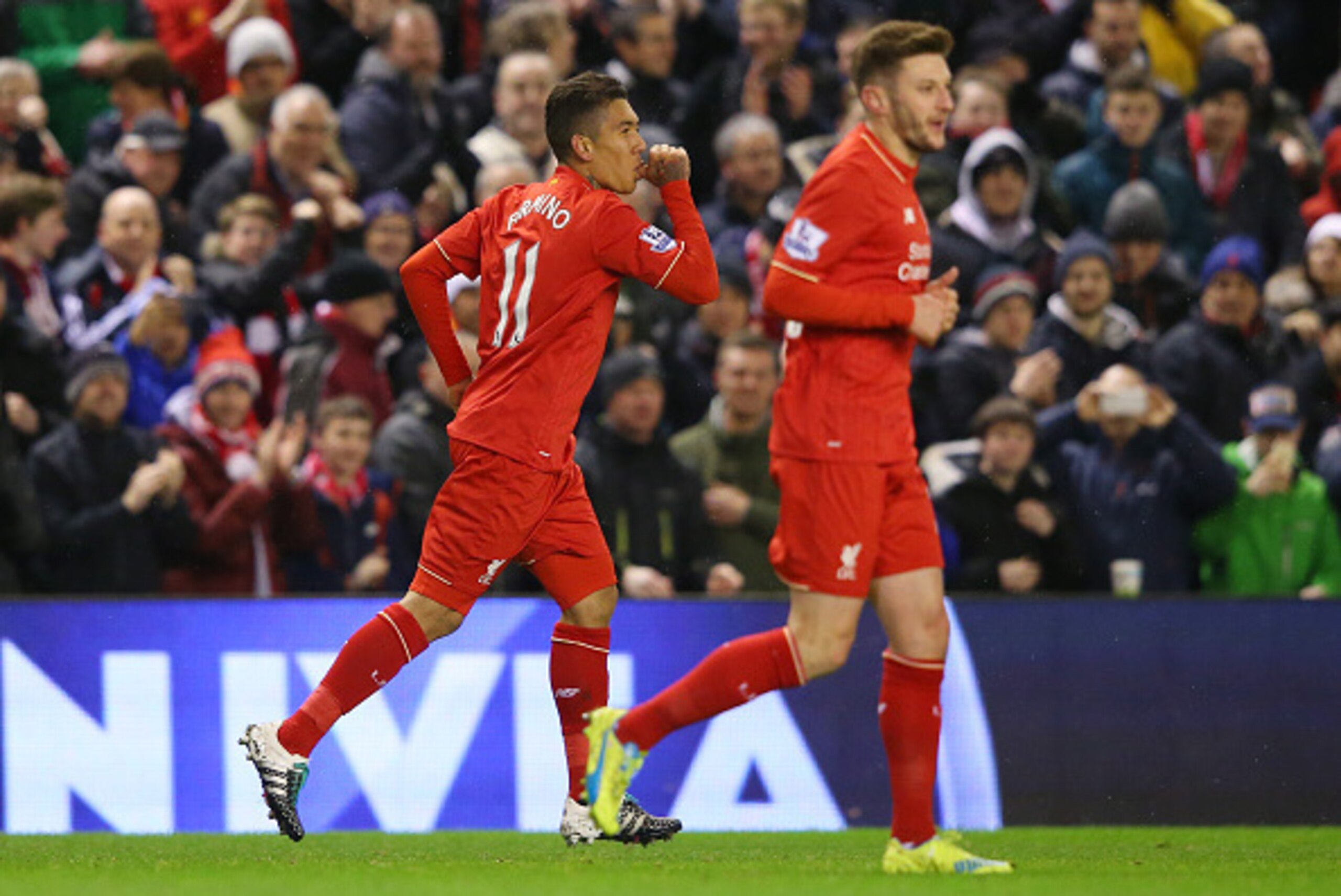 LIVERPOOL, ENGLAND - JANUARY 13:  Roberto Firmino (L) of Liverpool celebrates scoring his team's first goal with his team mate Adam Lallana (R) during the Barclays Premier League match between Liverpool and Arsenal at Anfield on January 13, 2016 in Liverp