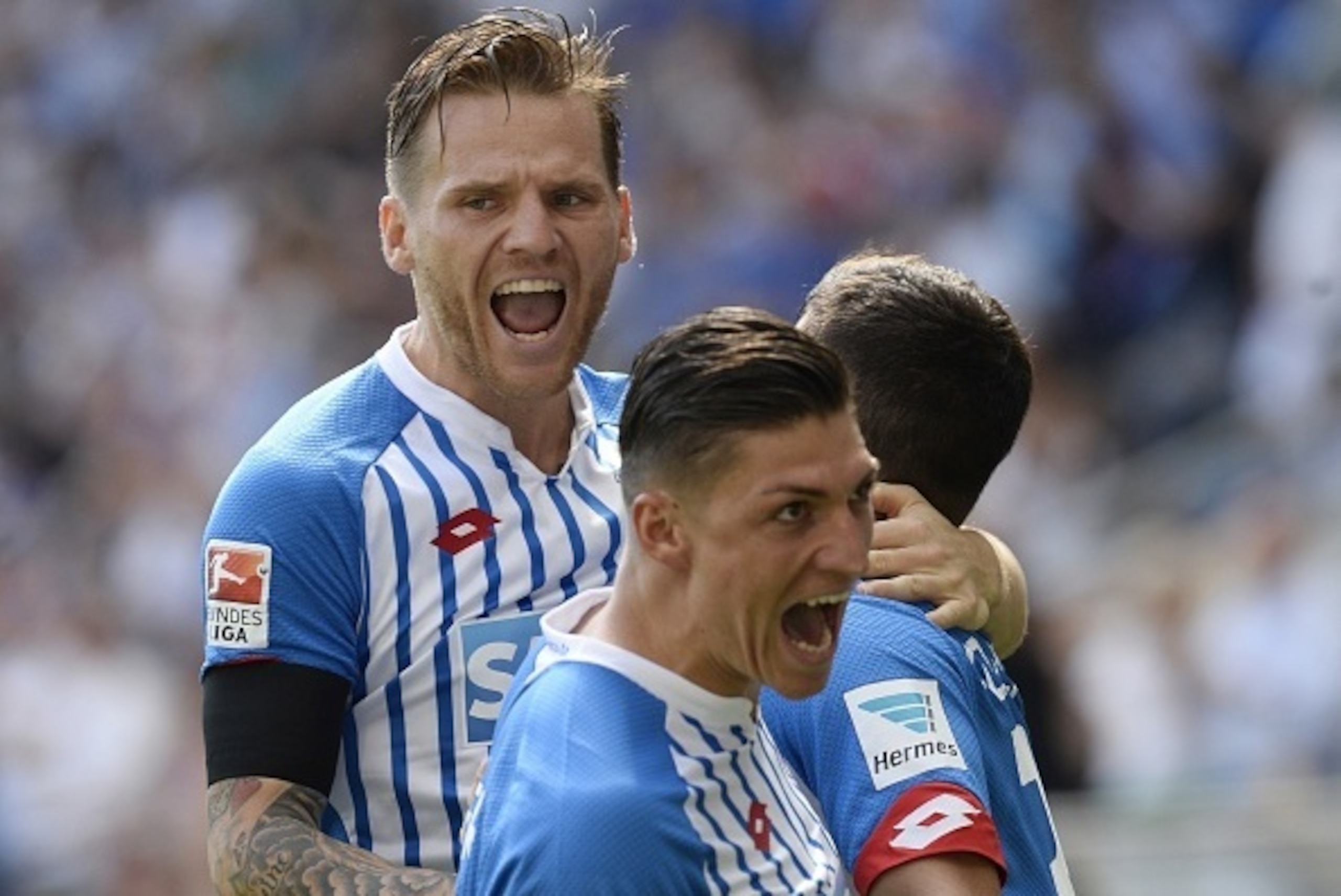 Hoffenheim's Polish midfielder Eugen Polanski (L) celebrates after teammate midfielder Kevin Volland (R) scored in the first minute during the German first division Bundesliga football match 1899 Hoffenheim vs FC Bayern Munich, on August 22, 2015 in Sinsh