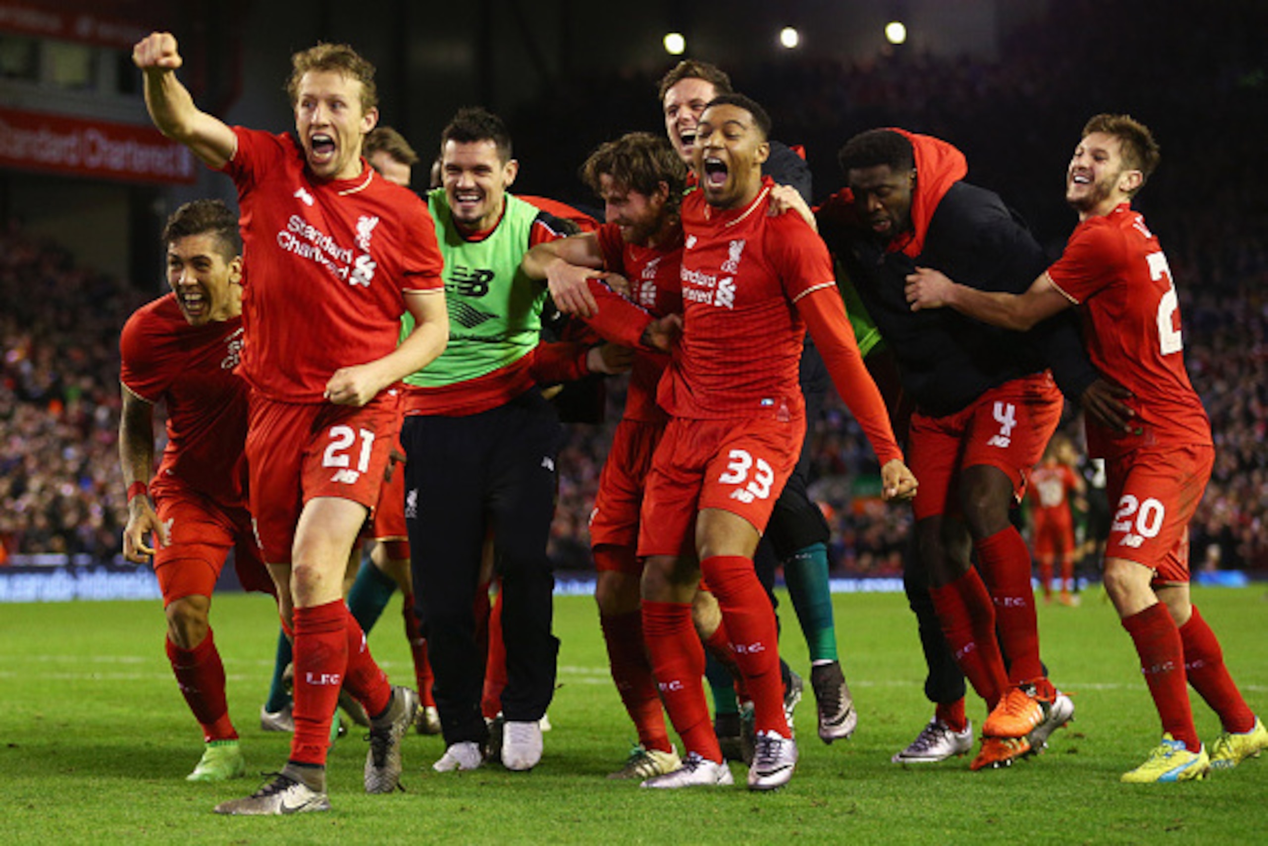 LIVERPOOL, ENGLAND - JANUARY 26:  Joe Allen of Liverpool (C) is congratulated by team mates as he scores the decisive penalty in the shoot out during the Capital One Cup semi final second leg match between Liverpool and Stoke City at Anfield on January 26