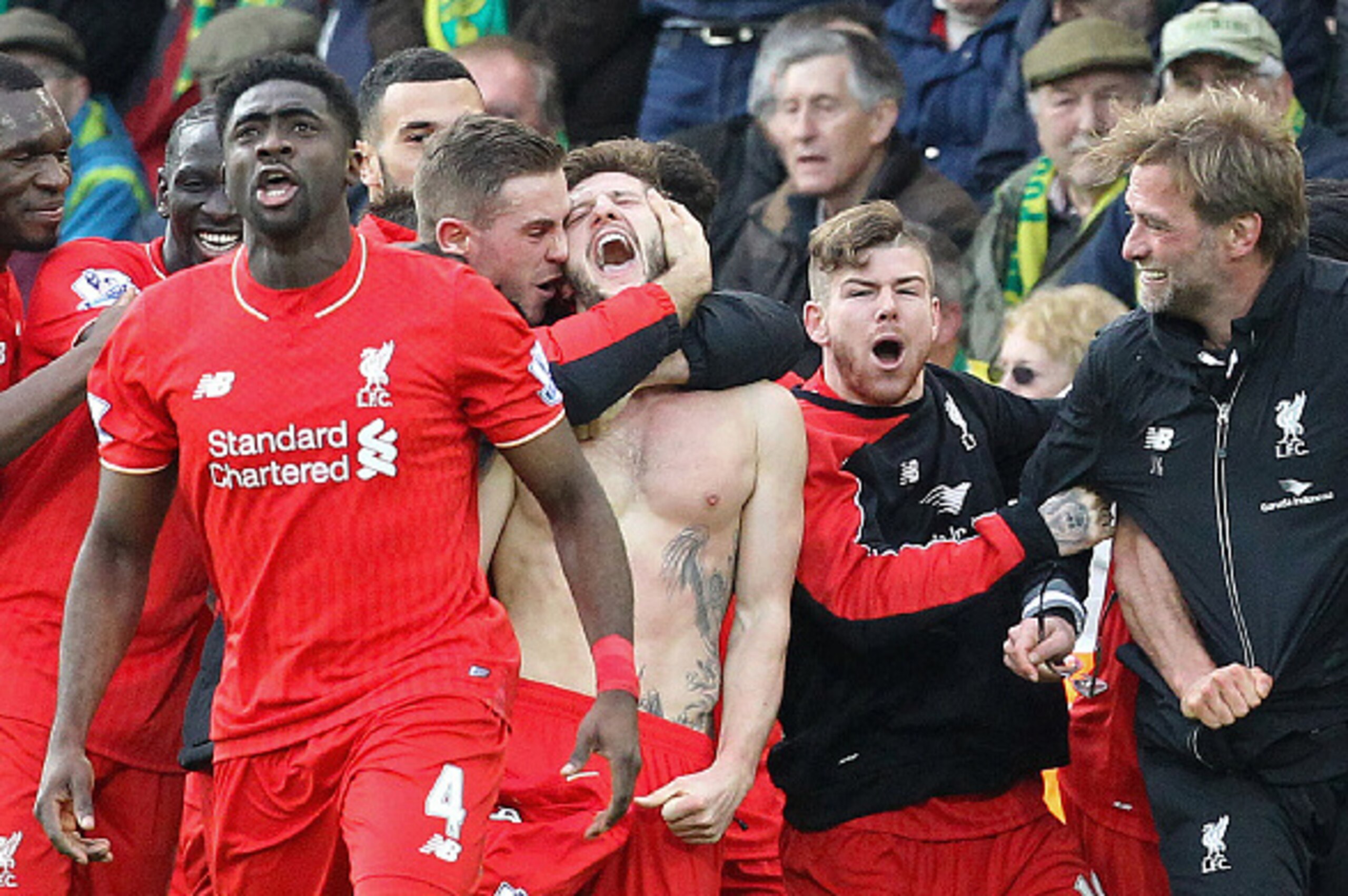 With his shirt off, Liverpool's English midfielder Adam Lallana (C) celebrates scoring their late winning goal with teammates and Liverpool's German manager Jurgen Klopp (3rd R), as Norwich City's Scottish coach Alex Neil (R) looks on during the English P