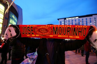 MANCHESTER, ENGLAND - DECEMBER 28:  A fan poses with a Manchester United scarf displaying the image and name of former Chelsea manager Jose Mourinho, outside the stadium before the Barclays Premier League match between Manchester United and Chelsea at Old