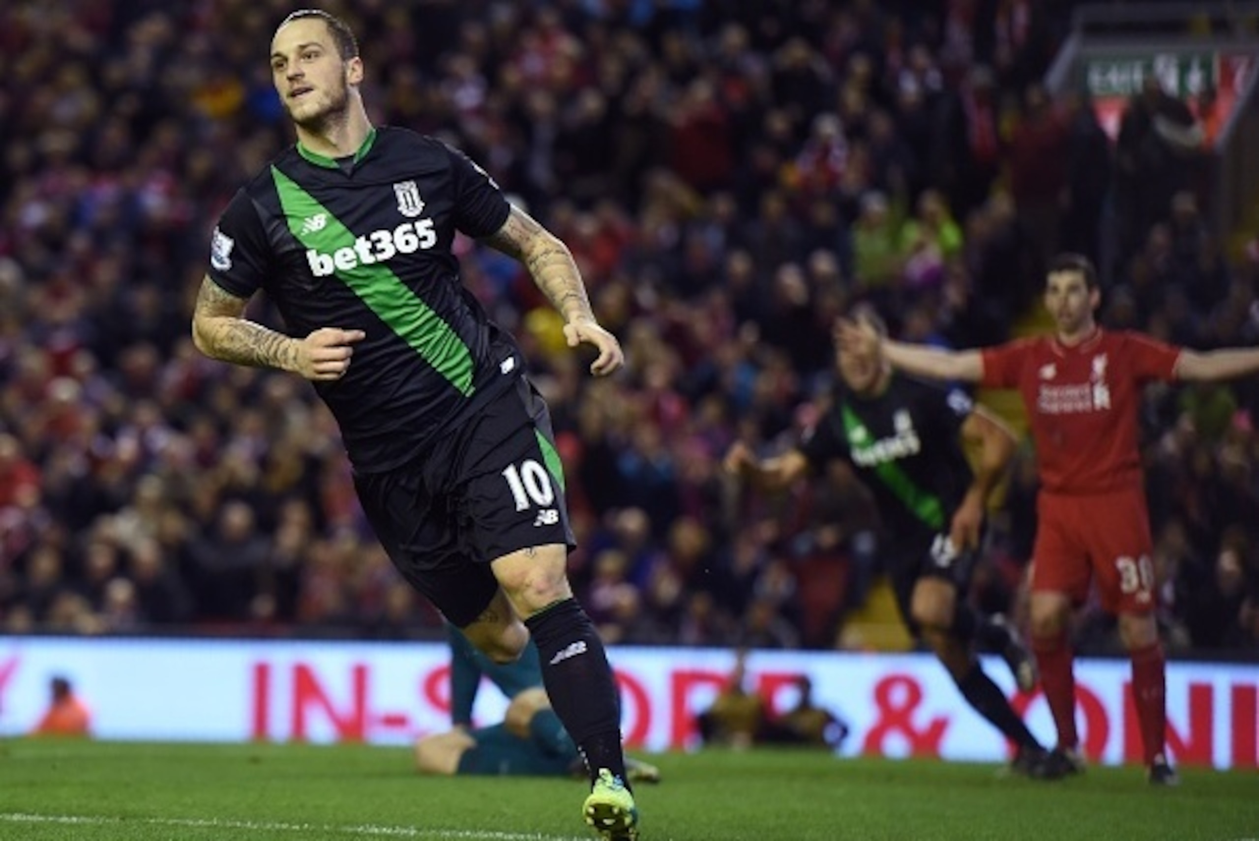 Stoke City's Austrian striker Marko Arnautovic celebrates after scoring the opening goal as Liverpool's English defender Jon Flanagan (R) appeals for offside during the English League Cup semi-final second leg football match between Liverpool and Stoke Ci