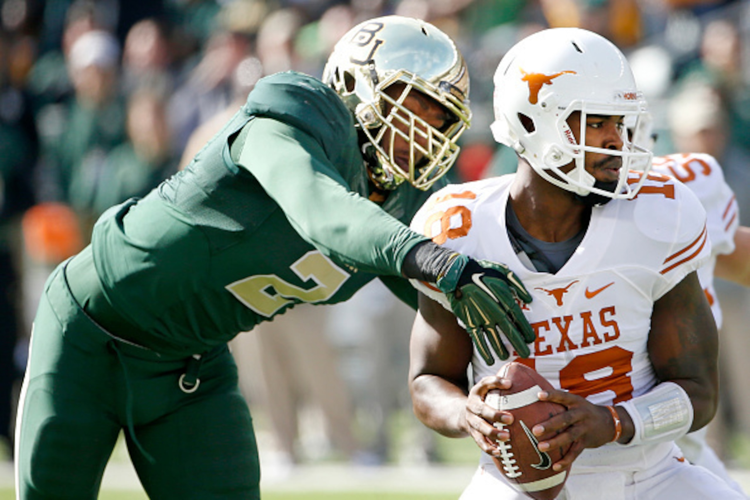 WACO, TX - DECEMBER 5:  Tyrone Swoopes #18 of the Texas Longhorns eludes Shawn Oakman #2 of the Baylor Bears in the first quarter at McLane Stadium on December 5, 2015 in Waco, Texas. (Photo by Ron Jenkins/Getty Images)