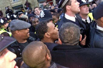 LONDON, UNITED KINGDOM:  Former undisputed world heavyweight Boxer Mike Tyson, who is in Britain for a forthcoming fight, is shielded by police and minders as he  tries to make a tour of Brixton, South London, 21 January 2000. Local community leaders had 