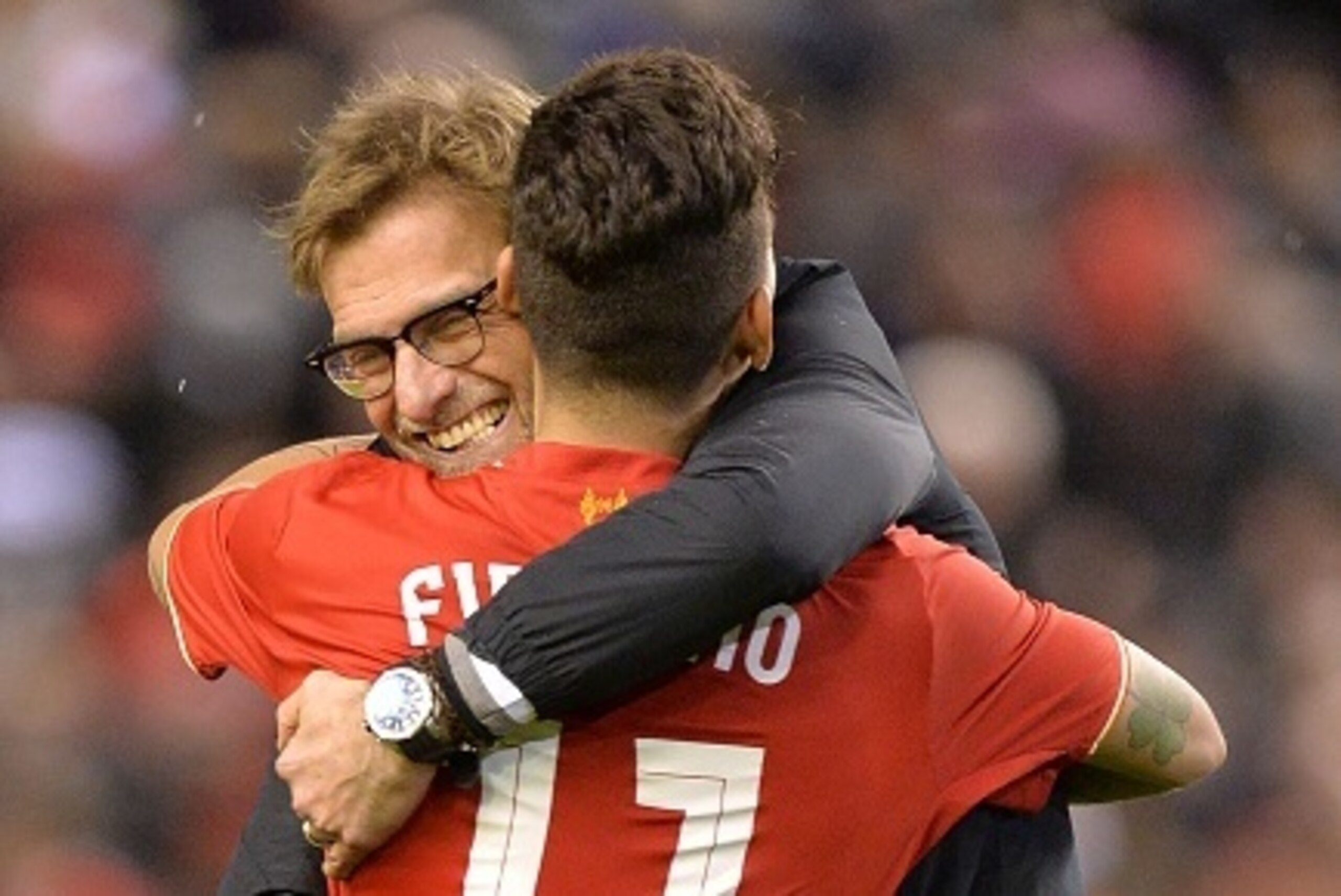 Liverpool's German manager Jurgen Klopp (L) embraces Liverpool's Brazilian midfielder Roberto Firmino after winning the penalty shoot-out in the English League Cup semi-final second leg football match between Liverpool and Stoke City at Anfield in Liverpo
