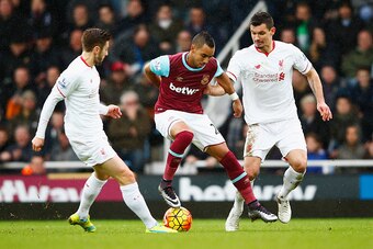LONDON, ENGLAND - JANUARY 02: Dimitri Payet (C) of West Ham United competes for the ball against Adam Lallana (L) and Dejan Lovren (R) of Liverpool during the Barclays Premier League match between West Ham United and Liverpool at Boleyn Ground on January 