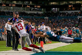 MIAMI GARDENS, FL - DECEMBER 14: Odell Beckham #13 of the New York Giants catches a touchdown pass as Brent Grimes #21 of the Miami Dolphins defends during the third quarter of the game at Sun Life Stadium on December 14, 2015 in Miami Gardens, Florida.  