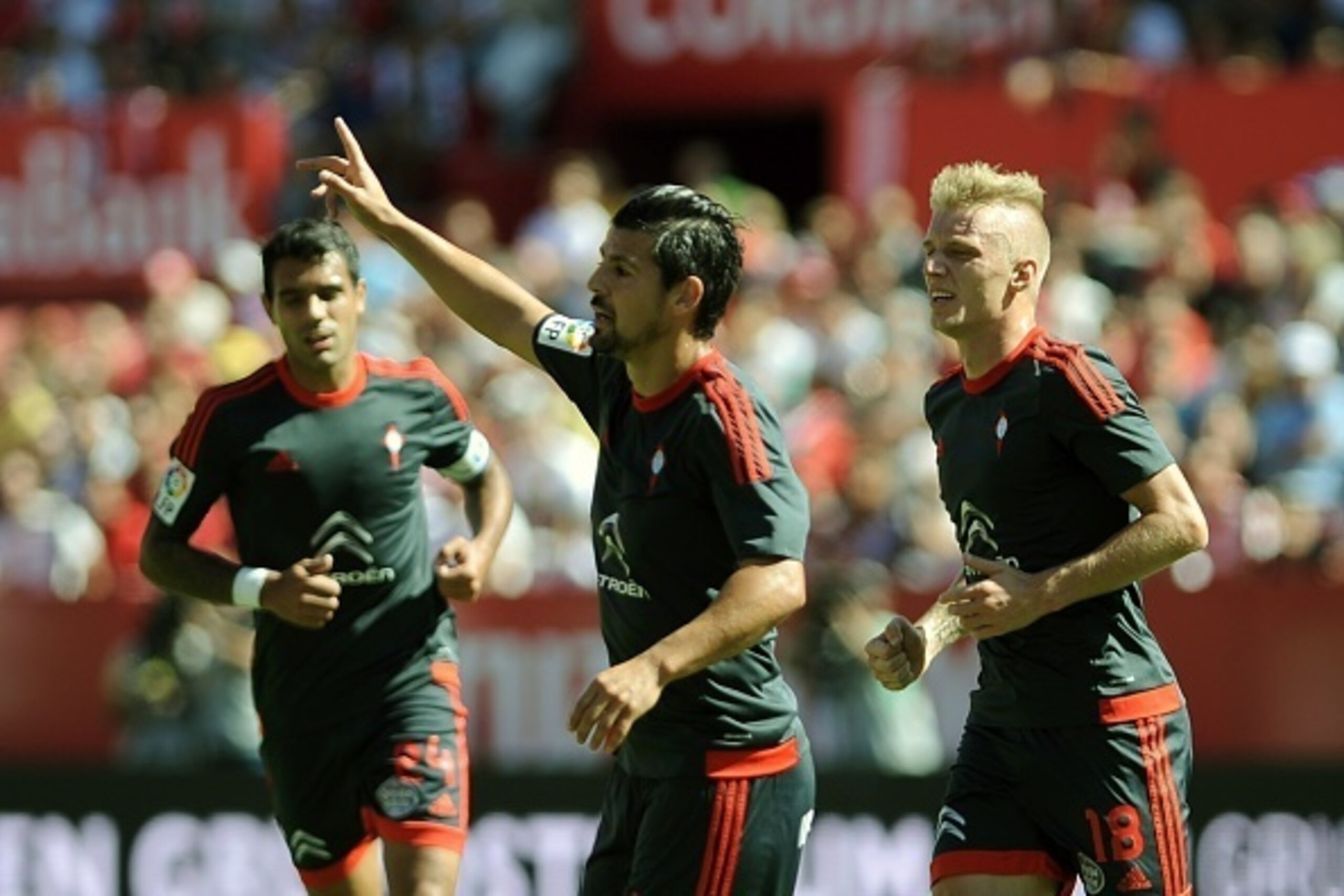 Celta Vigo's forward Nolito (C) celebrates a goal next to teammate Celta Vigo's Danish defender Daniel Wass (R) during the Spanish league football match Sevilla FC vs RC Celta de Vigo at the Ramon Sanchez Pizjuan stadium in Sevilla on September 20, 2015. 