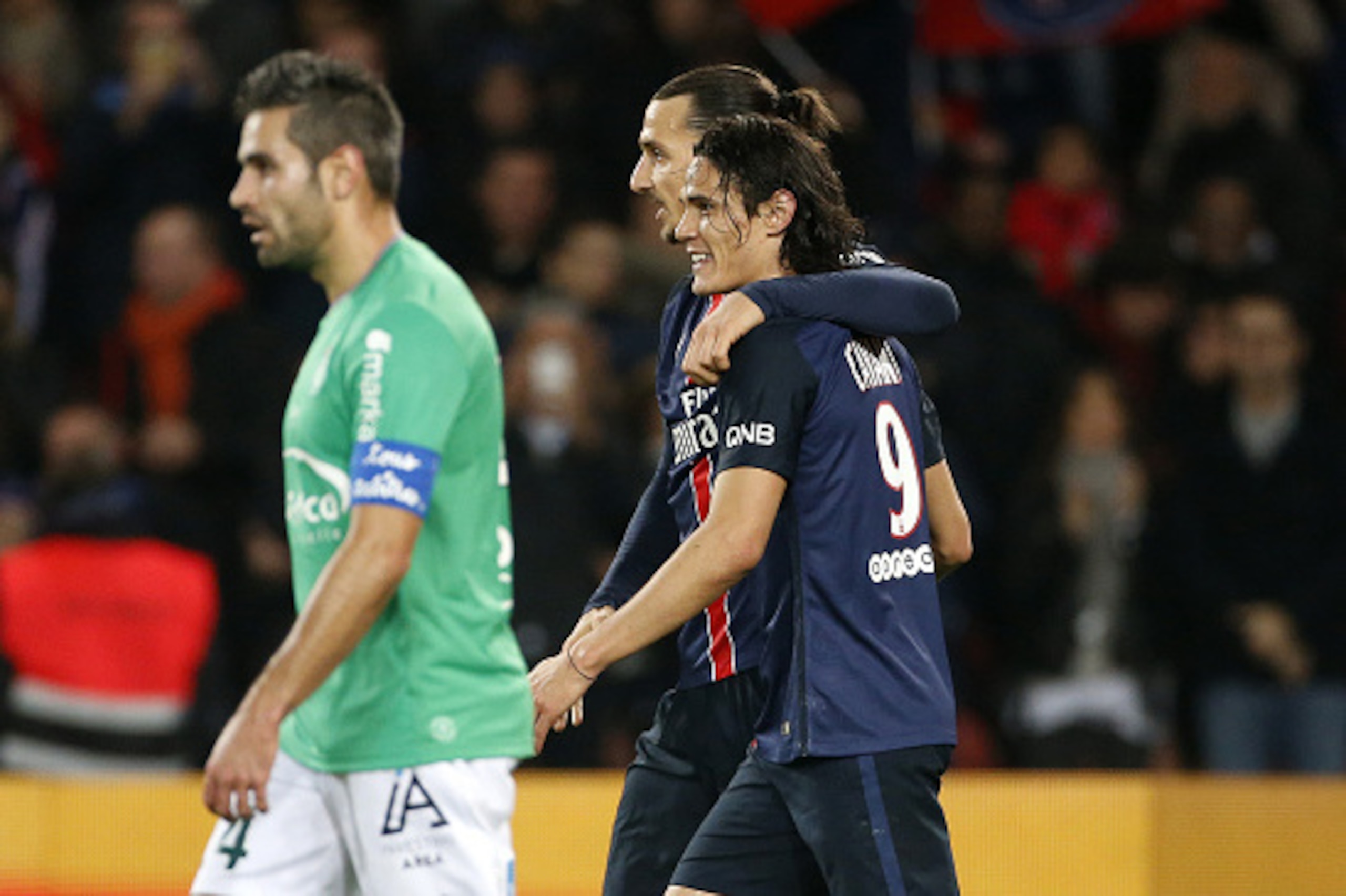 PARIS, FRANCE - OCTOBER 25: Zlatan Ibrahimovic of PSG celebrates scoring the 3rd goal for his team with teammate Edinson Cavani as Loic Perrin of Saint-Etienne (L) looks dejected during the French Ligue 1 match between Paris Saint-Germain (PSG) and AS Sai