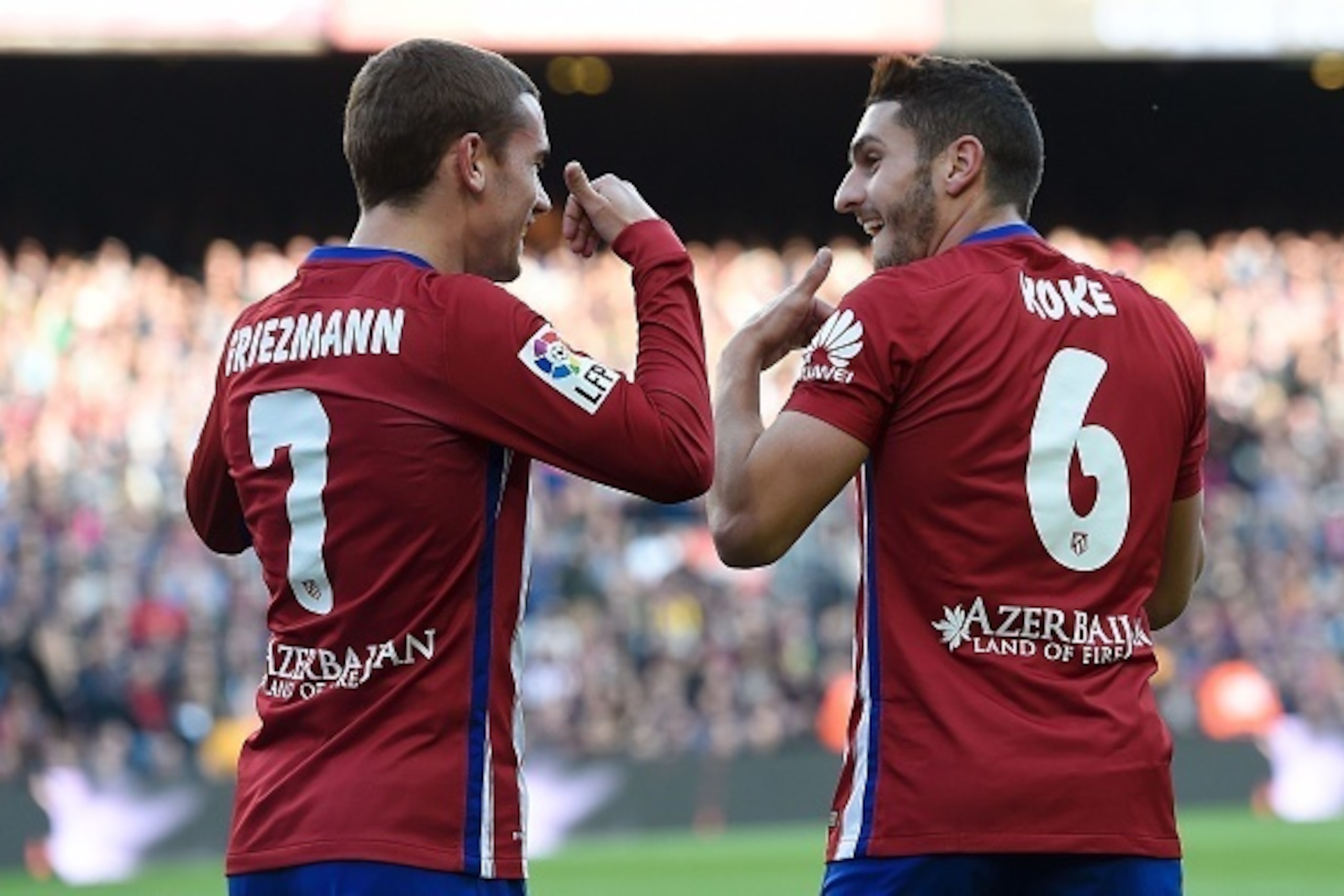 Atletico Madrid's midfielder Koke (R) celebrates with Atletico Madrid's French forward Antoine Griezmann after scoring during the Spanish league football match FC Barcelona vs Club Atletico de Madrid at the Camp Nou stadium in Barcelona on January 30, 201