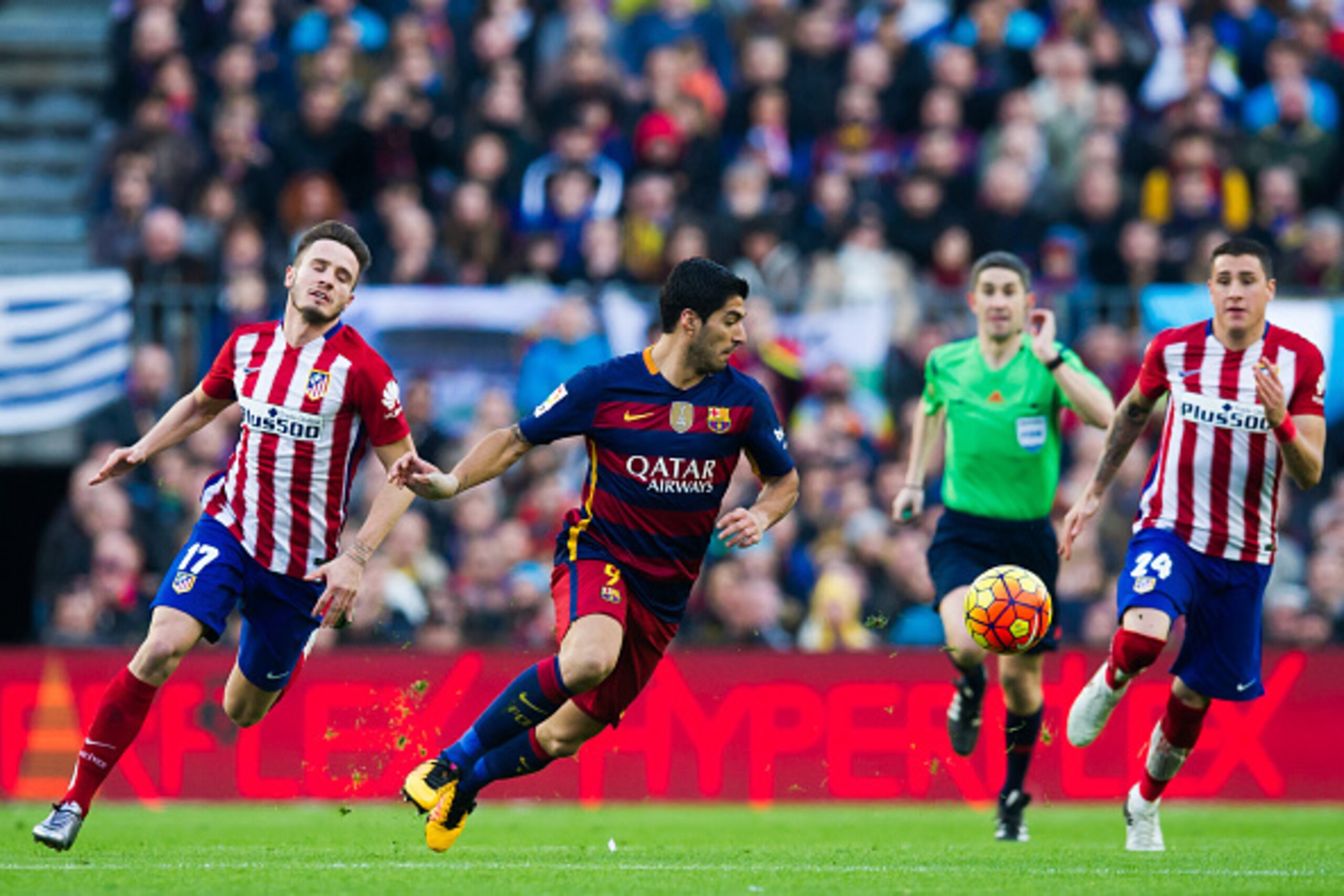 BARCELONA, SPAIN - JANUARY 30: Luis Suarez (C) of FC Barcelona conducts the ball between Saul Niguez (L) and Jose Maria Gimenez (R) of Club Atletico de Madrid during the La Liga match between FC Barcelona and Club Atletico de Madrid at Camp Nou on January