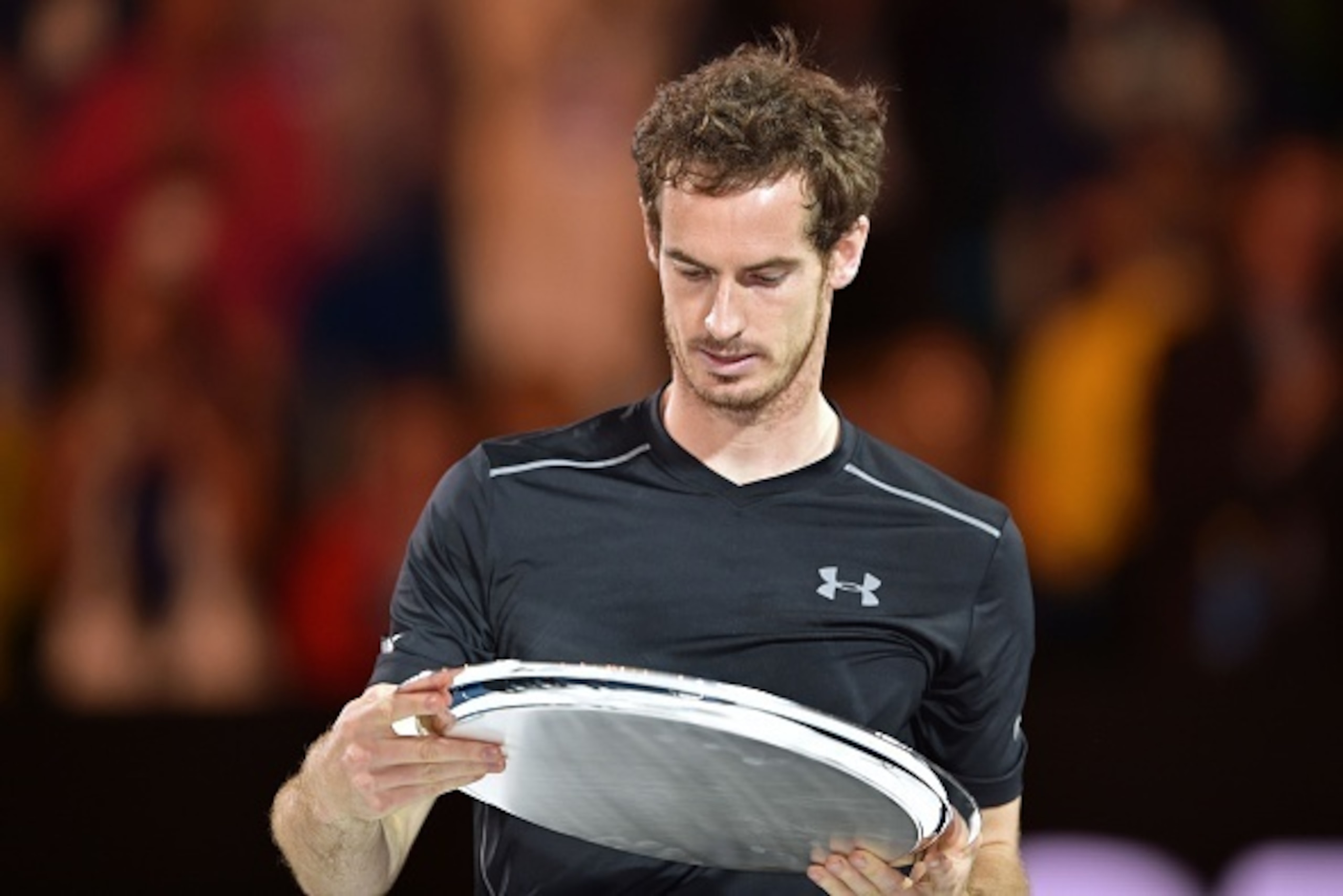 Britain's Andy Murray looks at his runners-up trophy during the presentation ceremony after his defeat during the men's singles final against Serbia's Novak Djokovic on day 14 of the 2016 Australian Open tennis tournament in Melbourne on January 31, 2016.