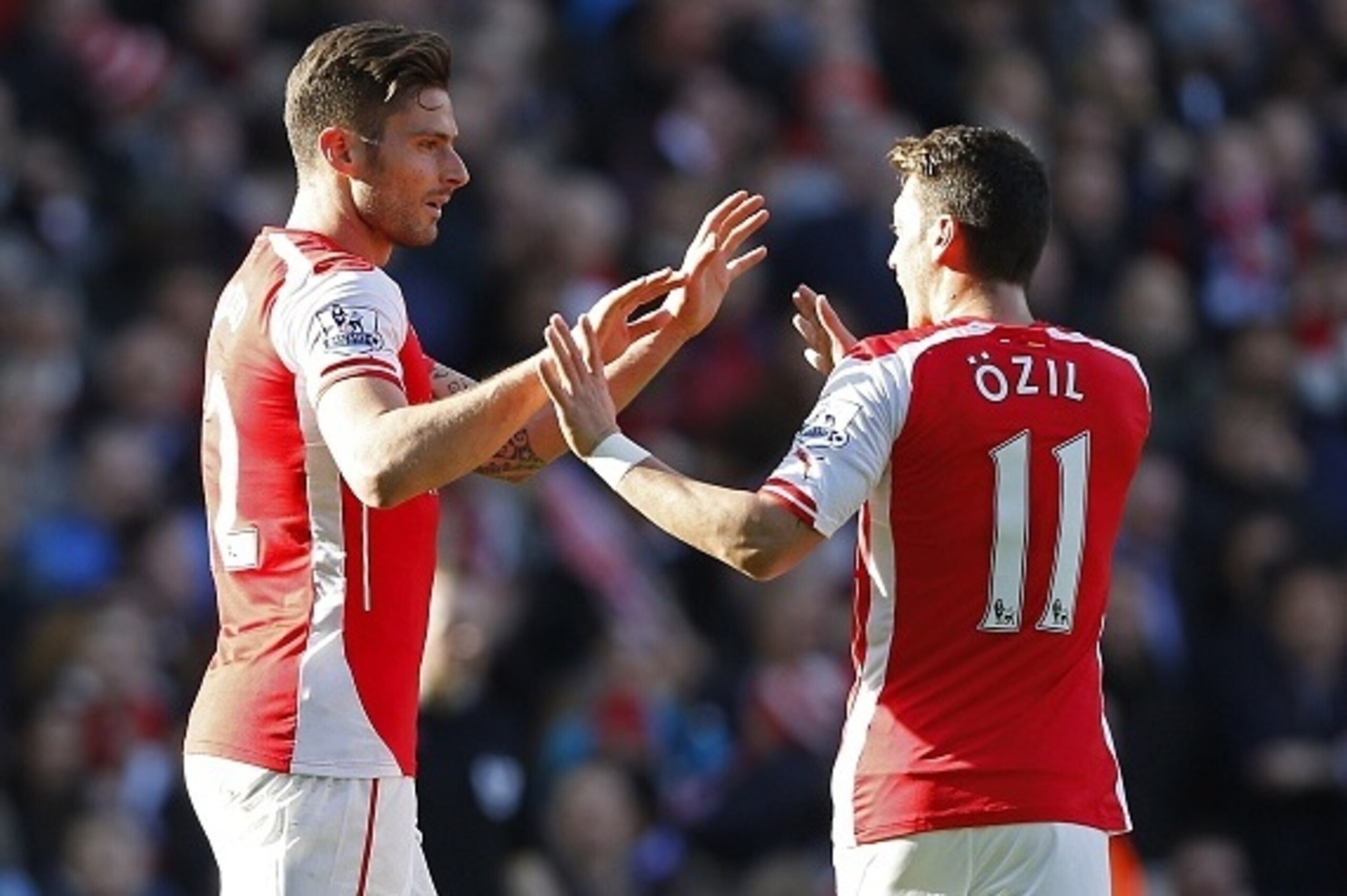 Arsenal's French striker Olivier Giroud (L) celebrates with Arsenal's German midfielder Mesut Ozil  after scoring the opening goal of the English Premier League football match between Arsenal and Everton at the Emirates stadium in London on March 1, 2015.