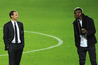 Juventus's French midfielder Paul Pogba (R) speaks with Juventus's coach Italian Massimiliano Allegri (L) at the Ramon Sanchez Pizjuan in Sevilla on December 7, 2015, on the eve of the UEFA Champions League Group D football match Sevilla FC vs Juventus.  