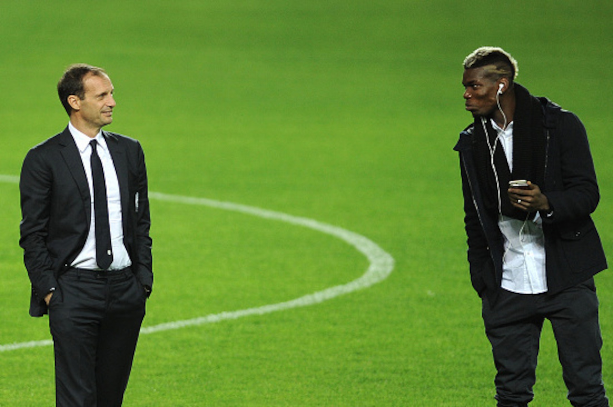 Juventus's French midfielder Paul Pogba (R) speaks with Juventus's coach Italian Massimiliano Allegri (L) at the Ramon Sanchez Pizjuan in Sevilla on December 7, 2015, on the eve of the UEFA Champions League Group D football match Sevilla FC vs Juventus.  