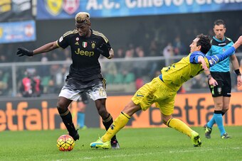 Juventus' midfielder from France Paul Pogba fights for the ball with Chievo's defender from Italy Dario Dainelli (R) during the Serie A football match between Chievo Verona and Juventus on January 31, 2016 at Bentegodi Stadium in Verona.  / AFP / GIUSEPPE