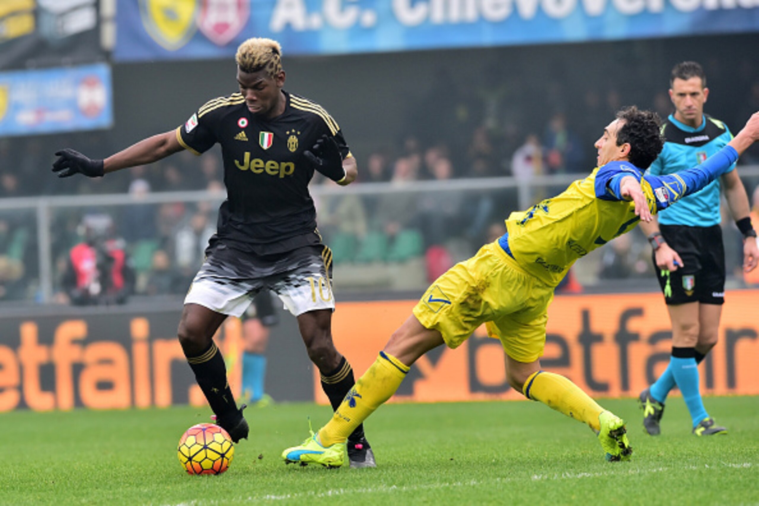 Juventus' midfielder from France Paul Pogba fights for the ball with Chievo's defender from Italy Dario Dainelli (R) during the Serie A football match between Chievo Verona and Juventus on January 31, 2016 at Bentegodi Stadium in Verona.  / AFP / GIUSEPPE